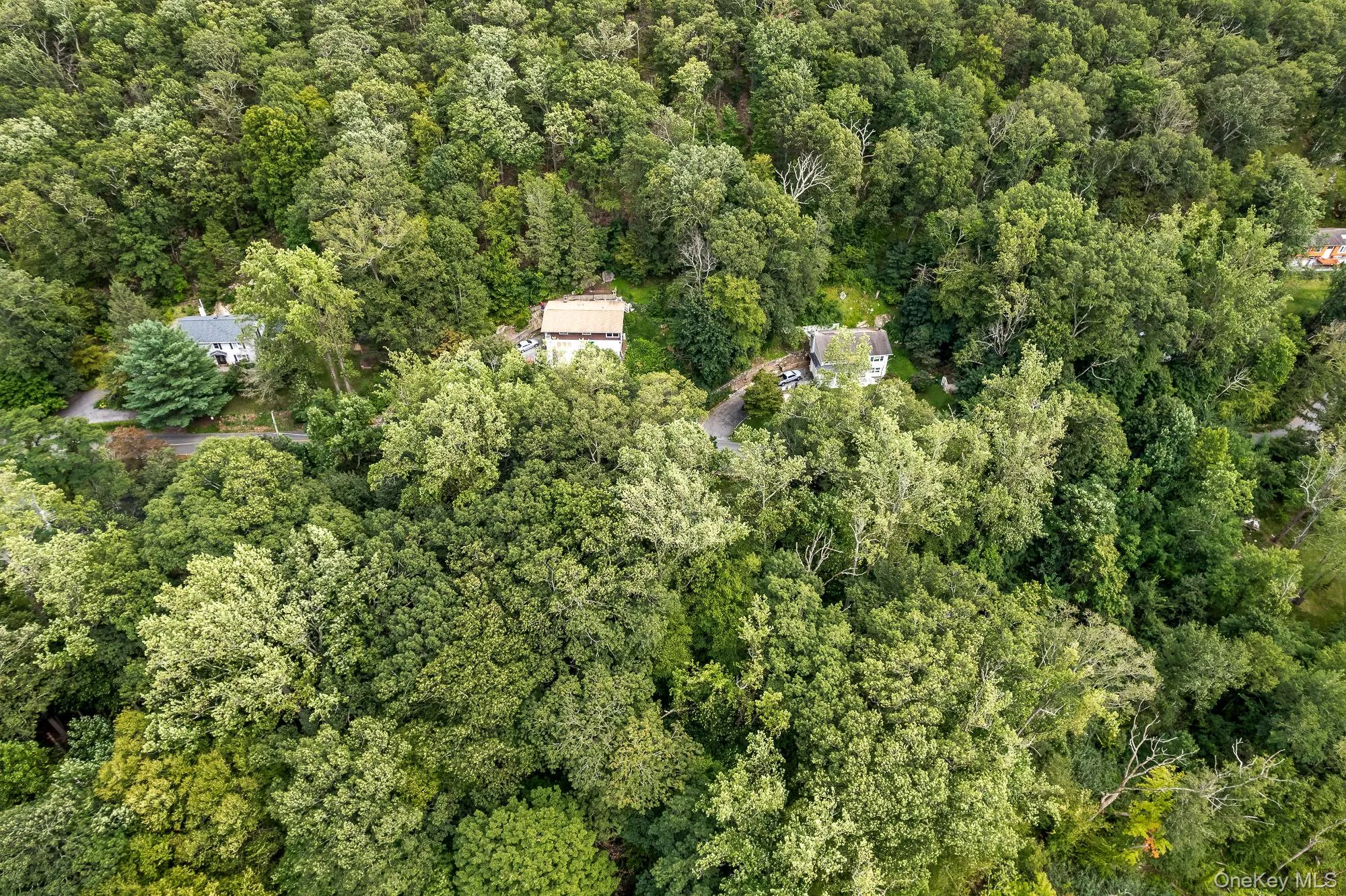 Aerial view of property and surrounding area with a heavily wooded area Aerial view of property and surrounding area with a heavily wooded area