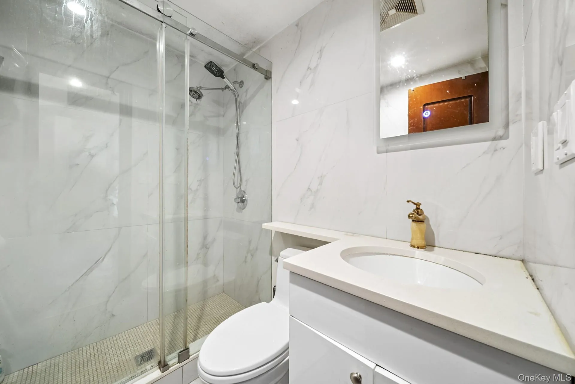 Bathroom featuring vanity and a marble finish shower Bathroom featuring vanity and a marble finish shower