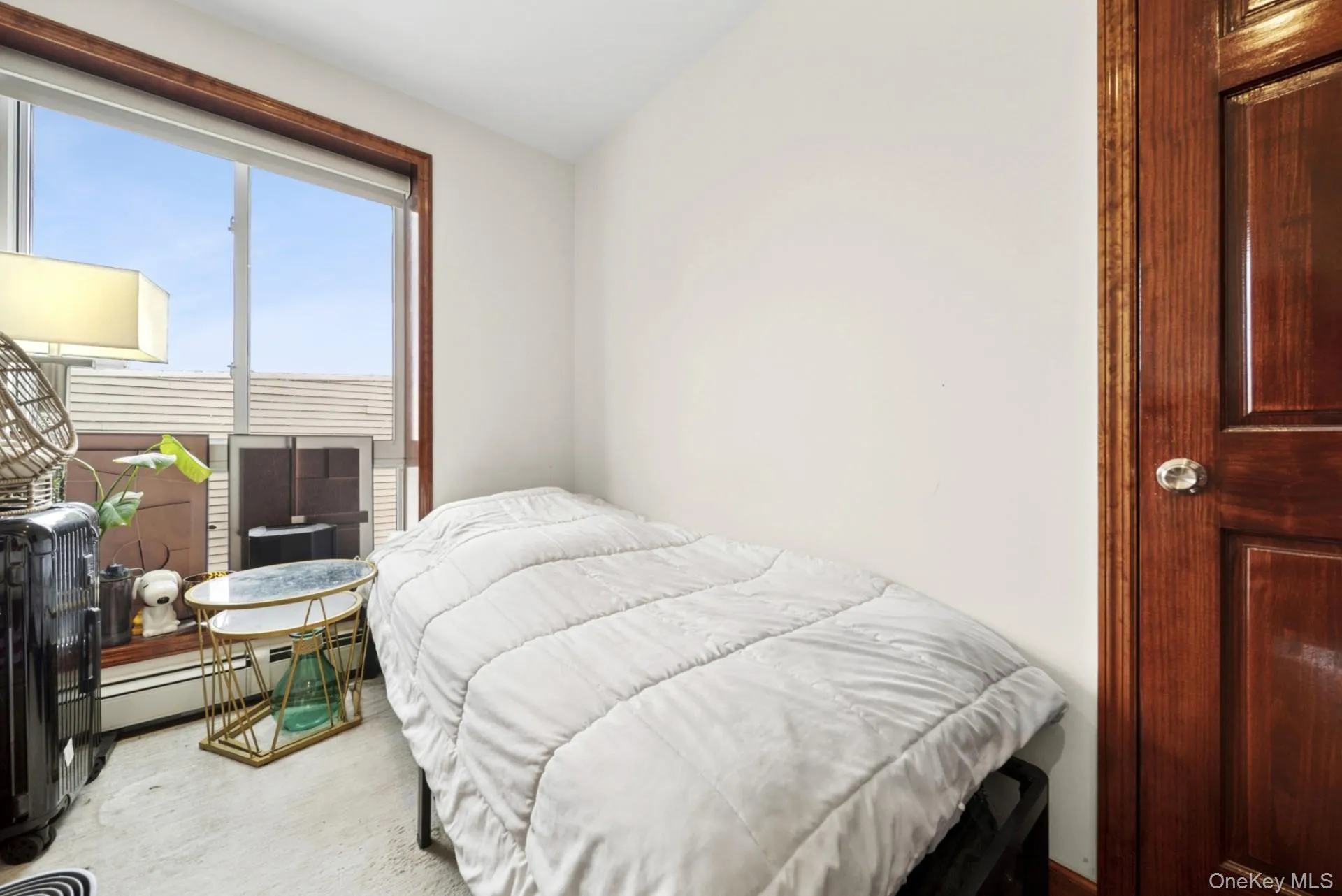 Bedroom featuring vaulted ceiling and a baseboard heating unit Bedroom featuring vaulted ceiling and a baseboard heating unit