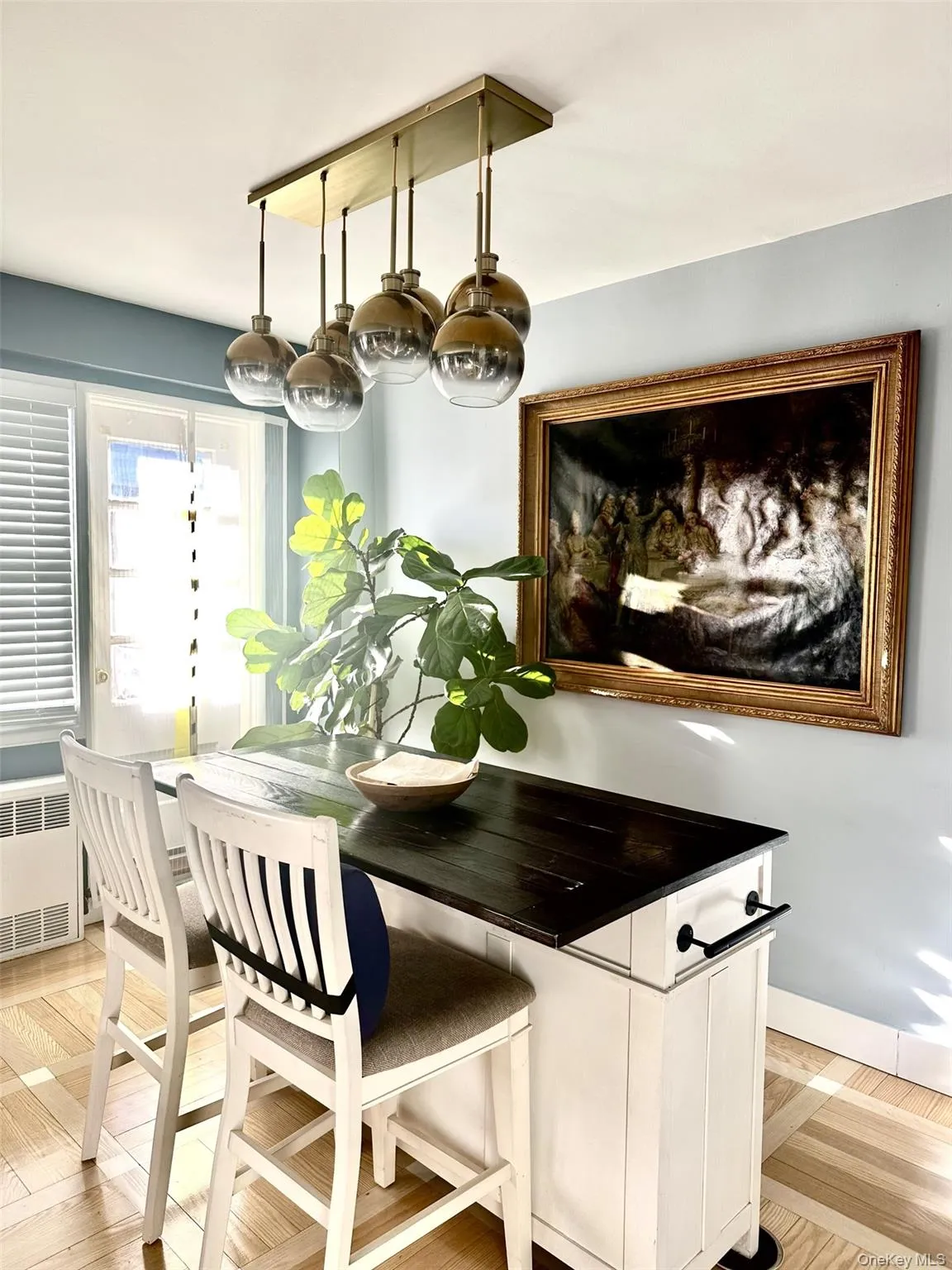 Dining room with light wood finished floors and radiator heating unit Dining room with light wood finished floors and radiator heating unit