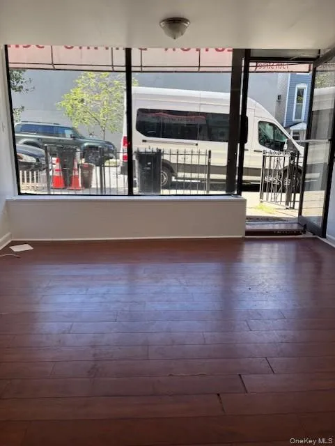 Unfurnished room featuring plenty of natural light and dark wood-type flooring Unfurnished room featuring plenty of natural light and dark wood-type flooring