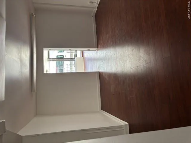 Empty room featuring dark wood finished floors and baseboards Empty room featuring dark wood finished floors and baseboards