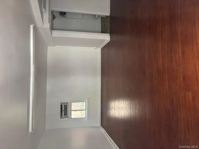 Unfurnished room featuring dark wood-style flooring and baseboards Unfurnished room featuring dark wood-style flooring and baseboards