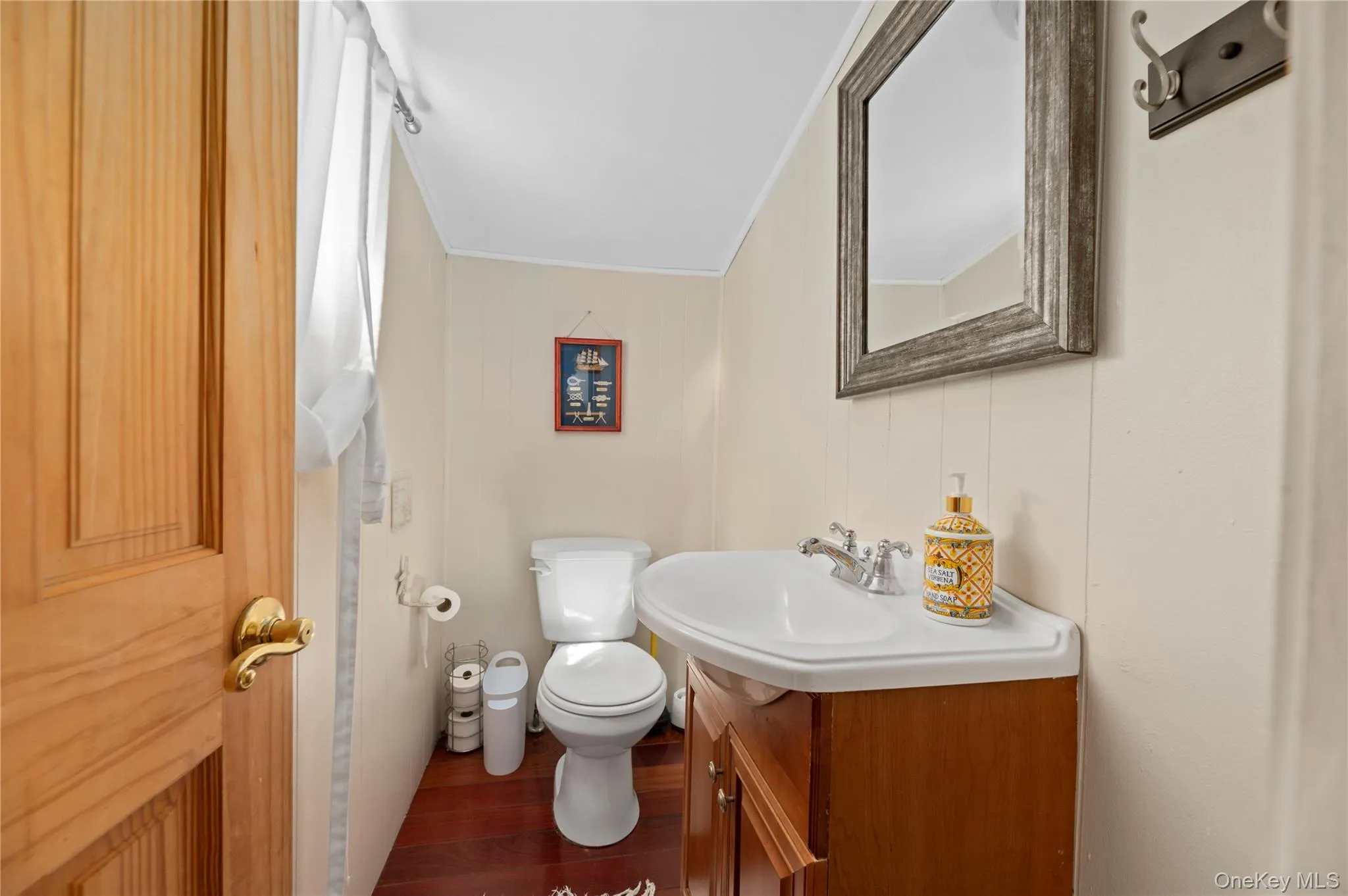 Bathroom with vanity, dark wood-type flooring, and crown molding Bathroom with vanity, dark wood-type flooring, and crown molding