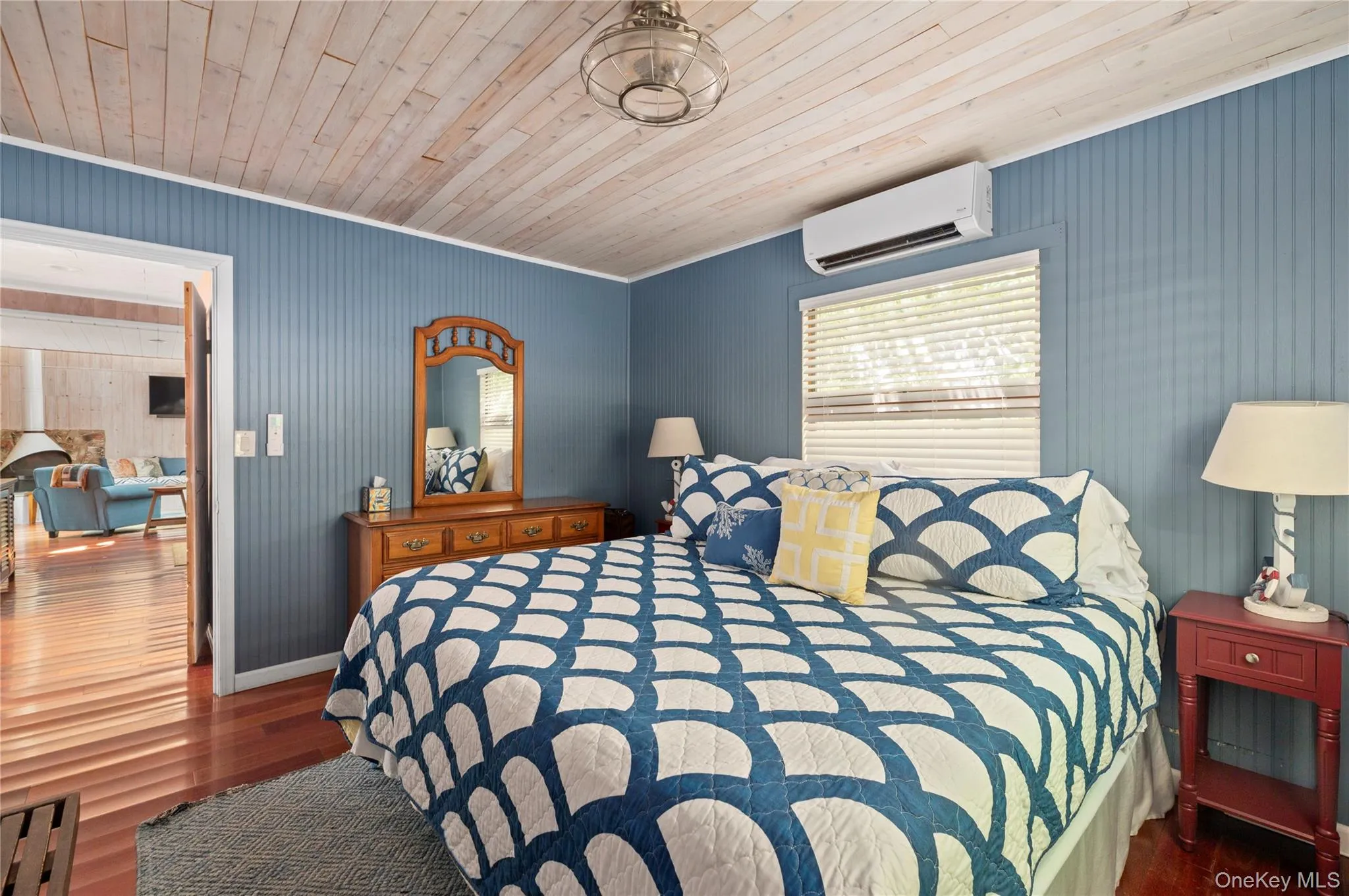 Bedroom with dark wood-type flooring, an AC wall unit, and wooden ceiling Bedroom with dark wood-type flooring, an AC wall unit, and wooden ceiling