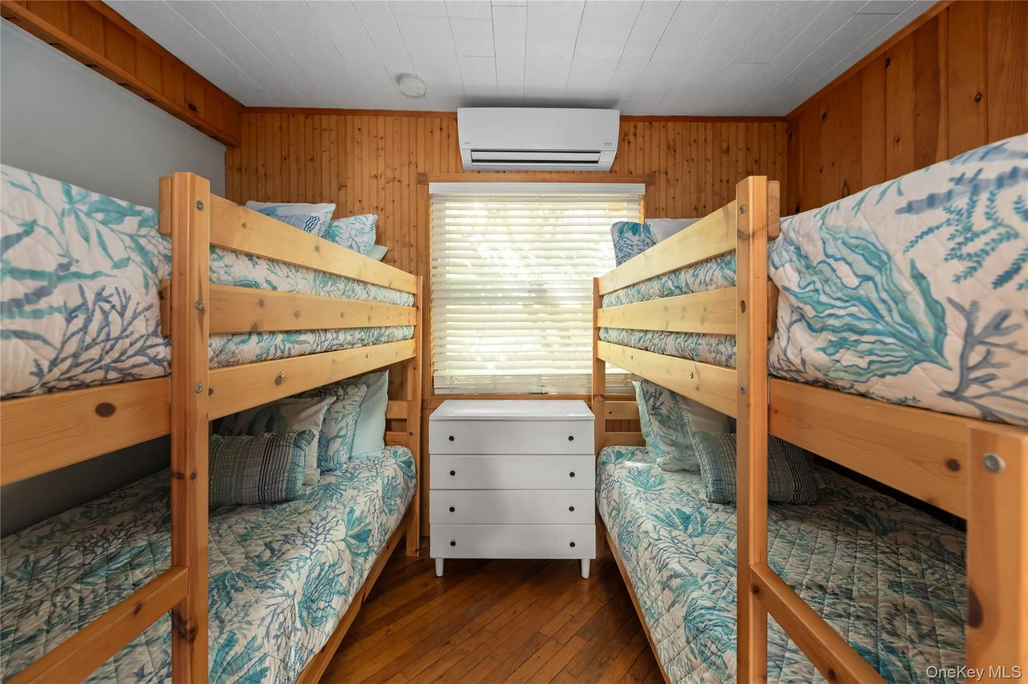 Bedroom with wooden walls, dark wood finished floors, an AC wall unit, and crown molding Bedroom with wooden walls, dark wood finished floors, an AC wall unit, and crown molding