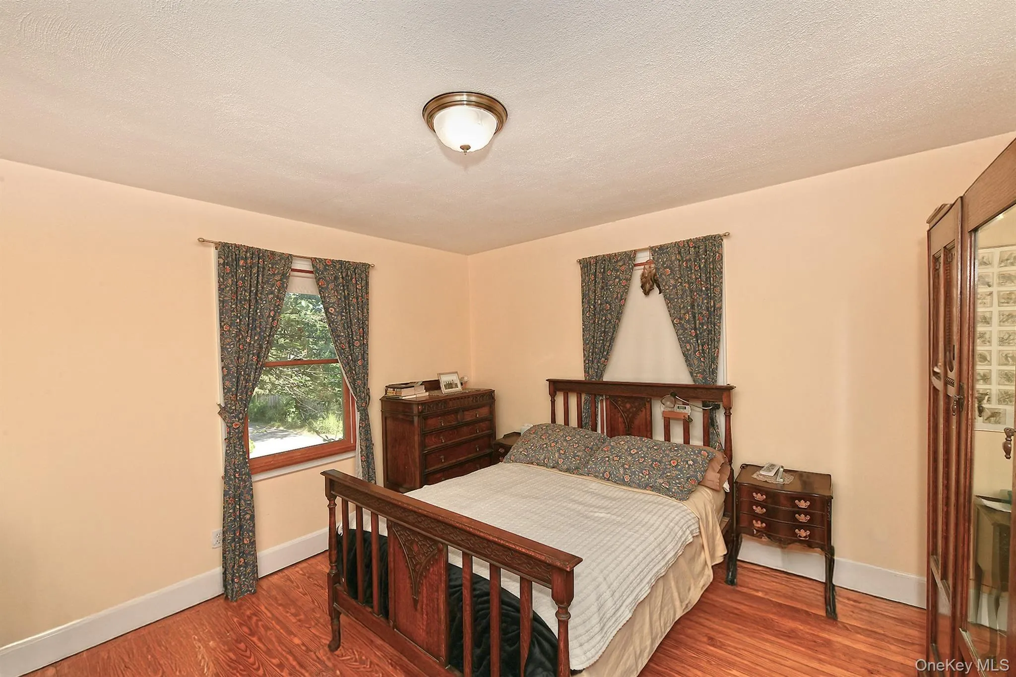 Bedroom featuring wood finished floors and a textured ceiling Bedroom featuring wood finished floors and a textured ceiling