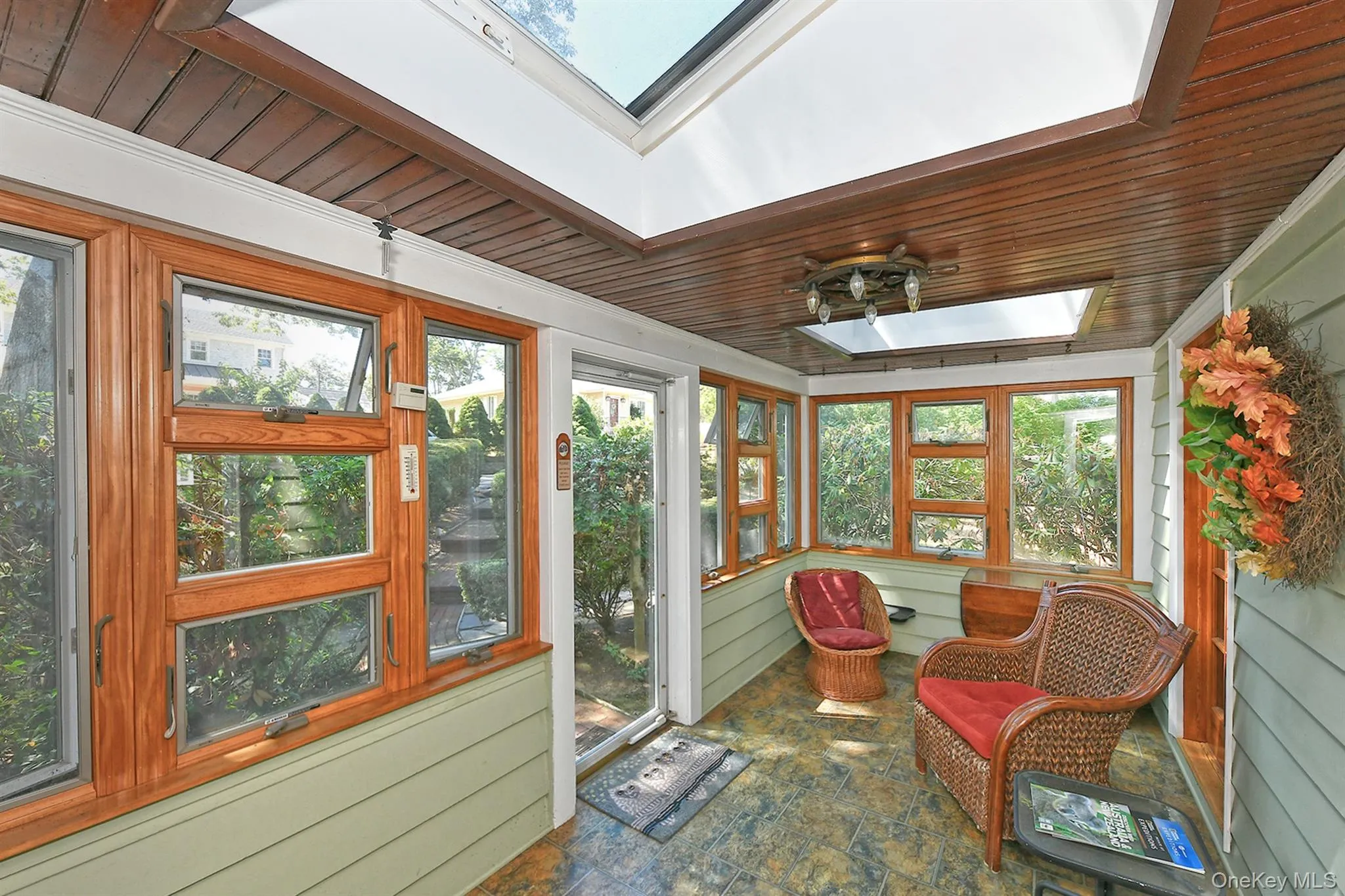 Sunroom / solarium with a skylight, plenty of natural light, wooden walls, wooden ceiling, and ornamental molding Sunroom / solarium with a skylight, plenty of natural light, wooden walls, wooden ceiling, and ornamental molding