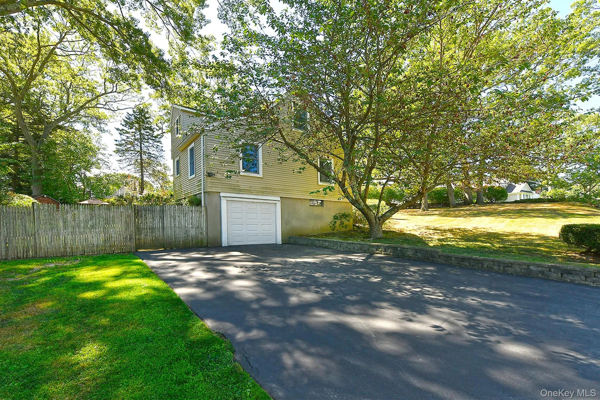 View of side of property featuring driveway and a garage View of side of property featuring driveway and a garage