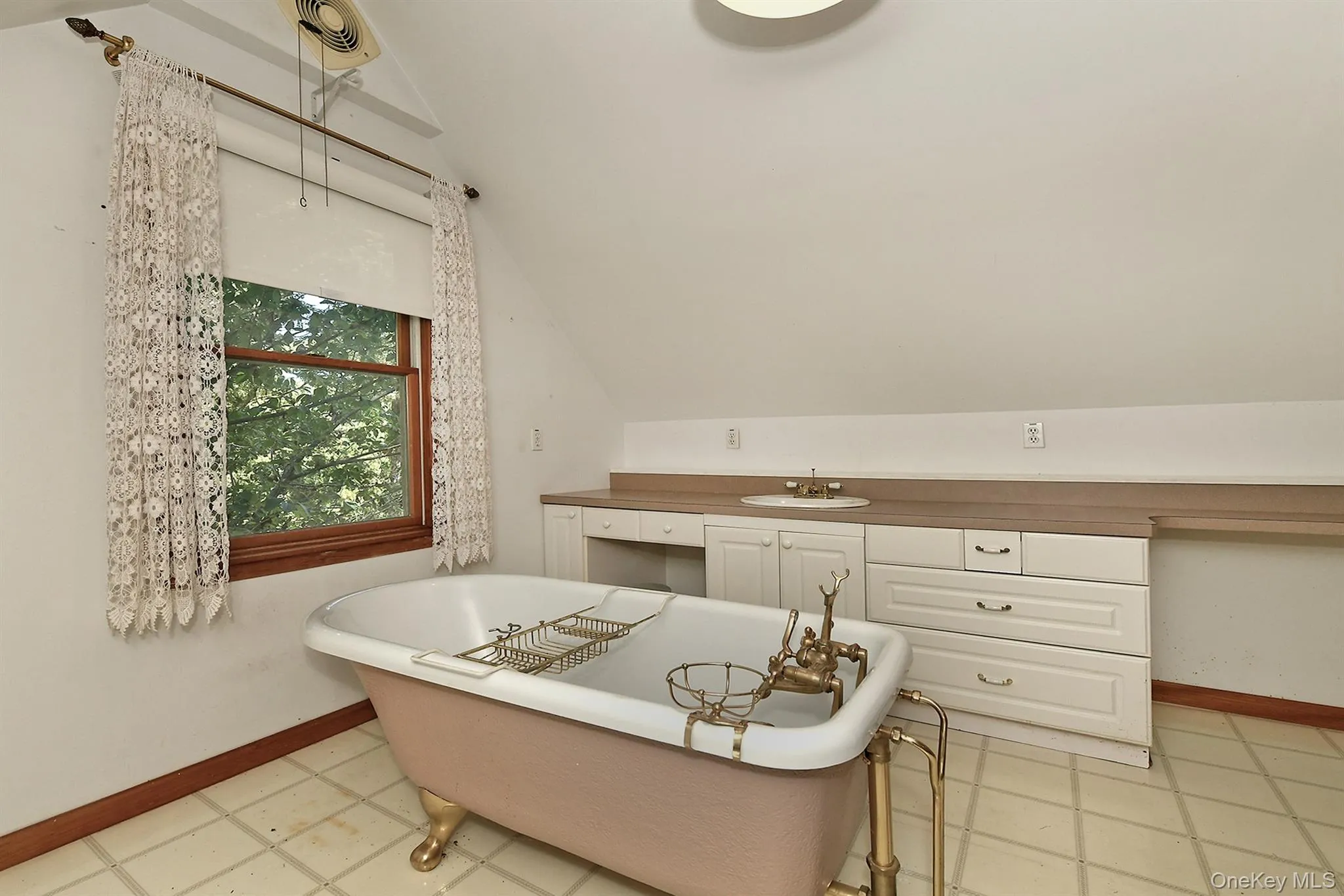 Bathroom with a freestanding bath, lofted ceiling, and vanity Bathroom with a freestanding bath, lofted ceiling, and vanity