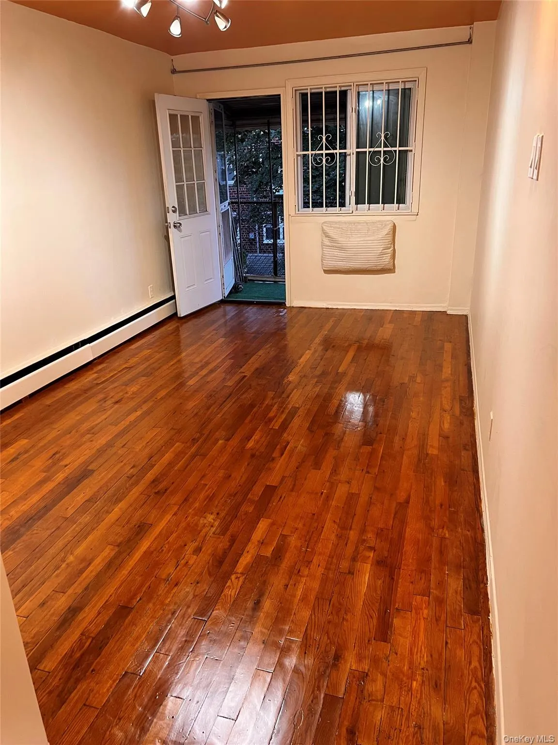 Spare room with hardwood / wood-style flooring and baseboard heating Spare room with hardwood / wood-style flooring and baseboard heating