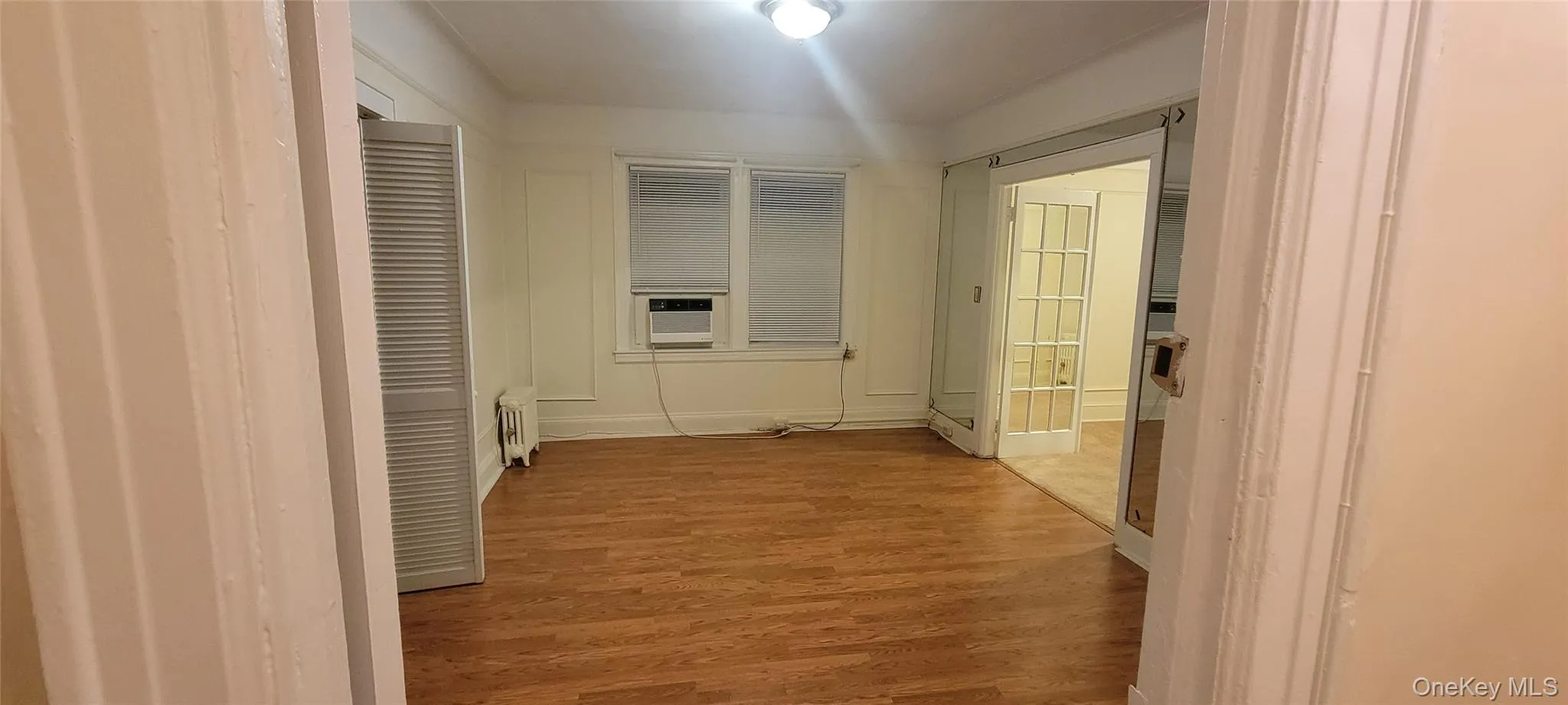 Hall with light wood finished floors and radiator heating unit Hall with light wood finished floors and radiator heating unit