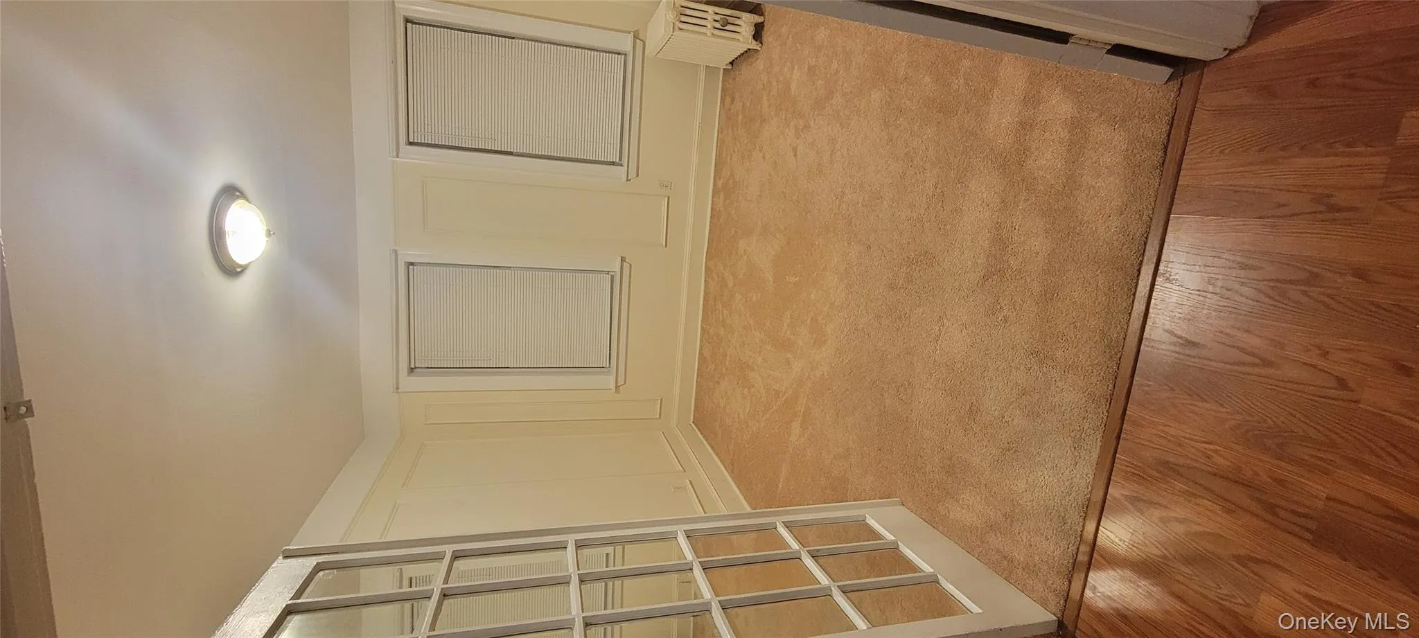 Hall with light wood-style flooring and a decorative wall Hall with light wood-style flooring and a decorative wall