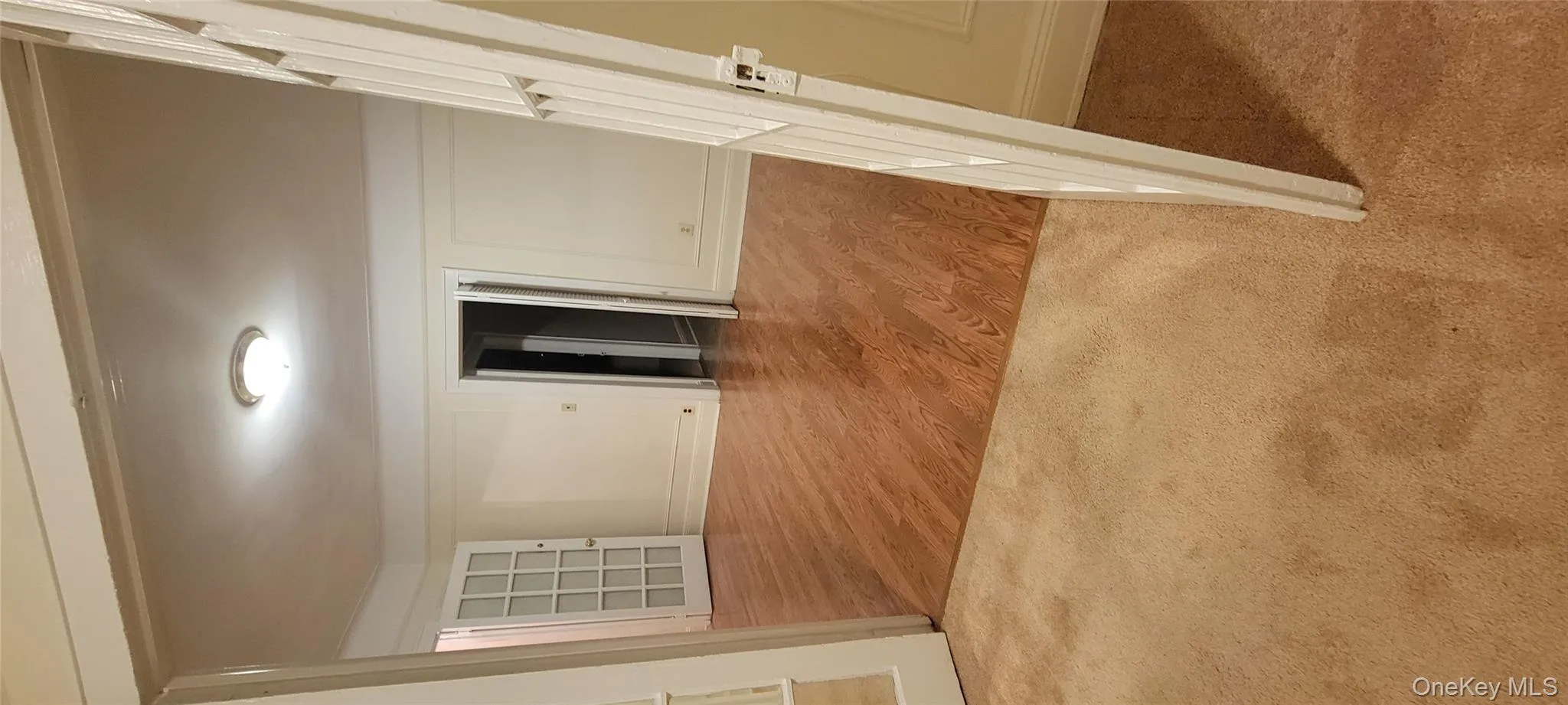 Corridor with light wood finished floors and light colored carpet Corridor with light wood finished floors and light colored carpet