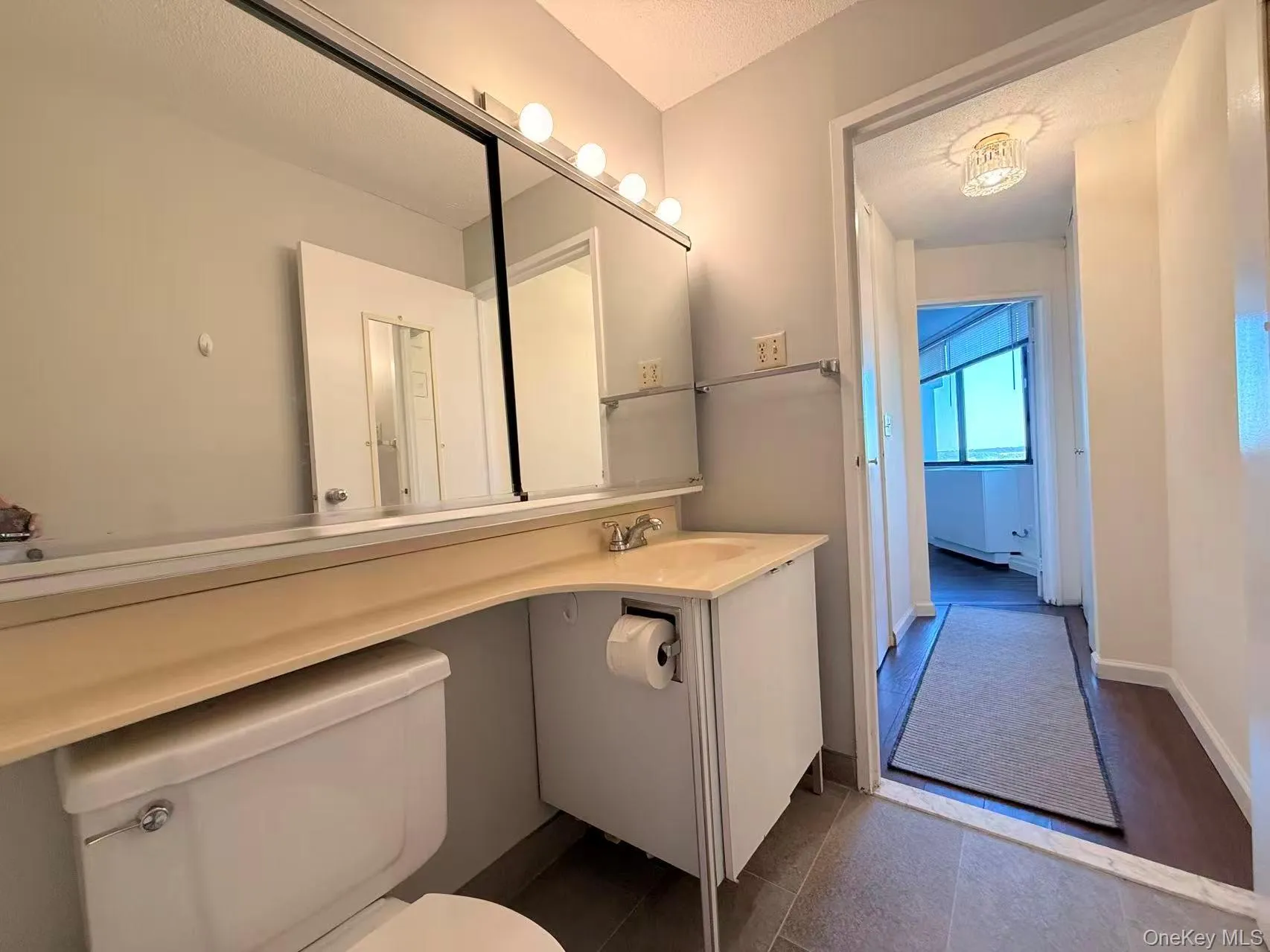 Half bathroom with vanity, a textured ceiling, and dark tile patterned flooring Half bathroom with vanity, a textured ceiling, and dark tile patterned flooring