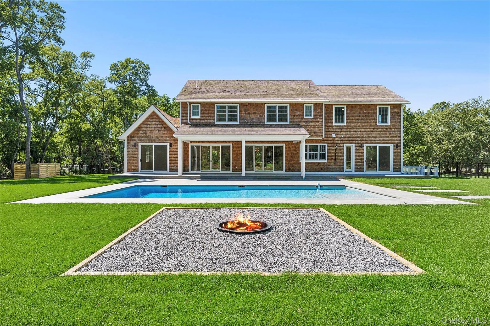 Rear view of property featuring an outdoor pool, a patio, and an outdoor fire pit Rear view of property featuring an outdoor pool, a patio, and an outdoor fire pit