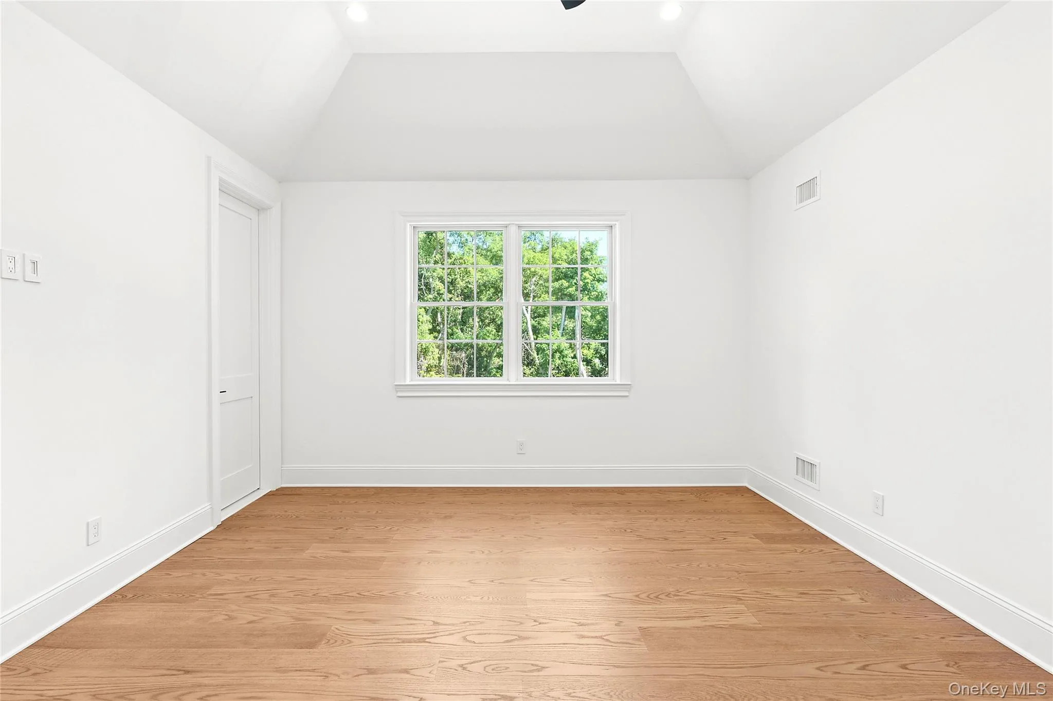 Unfurnished room with light wood finished floors, ceiling fan, and vaulted ceiling Unfurnished room with light wood finished floors, ceiling fan, and vaulted ceiling