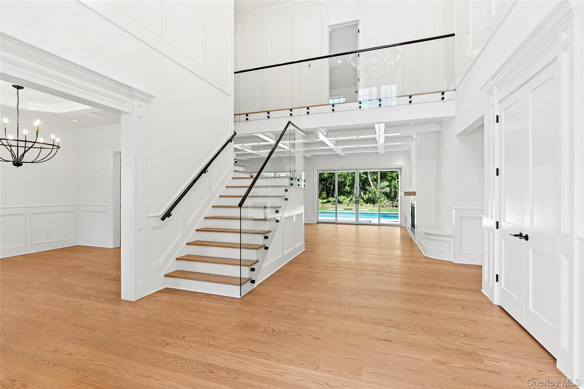 Stairway with a decorative wall, a chandelier, wainscoting, and wood finished floors Stairway with a decorative wall, a chandelier, wainscoting, and wood finished floors