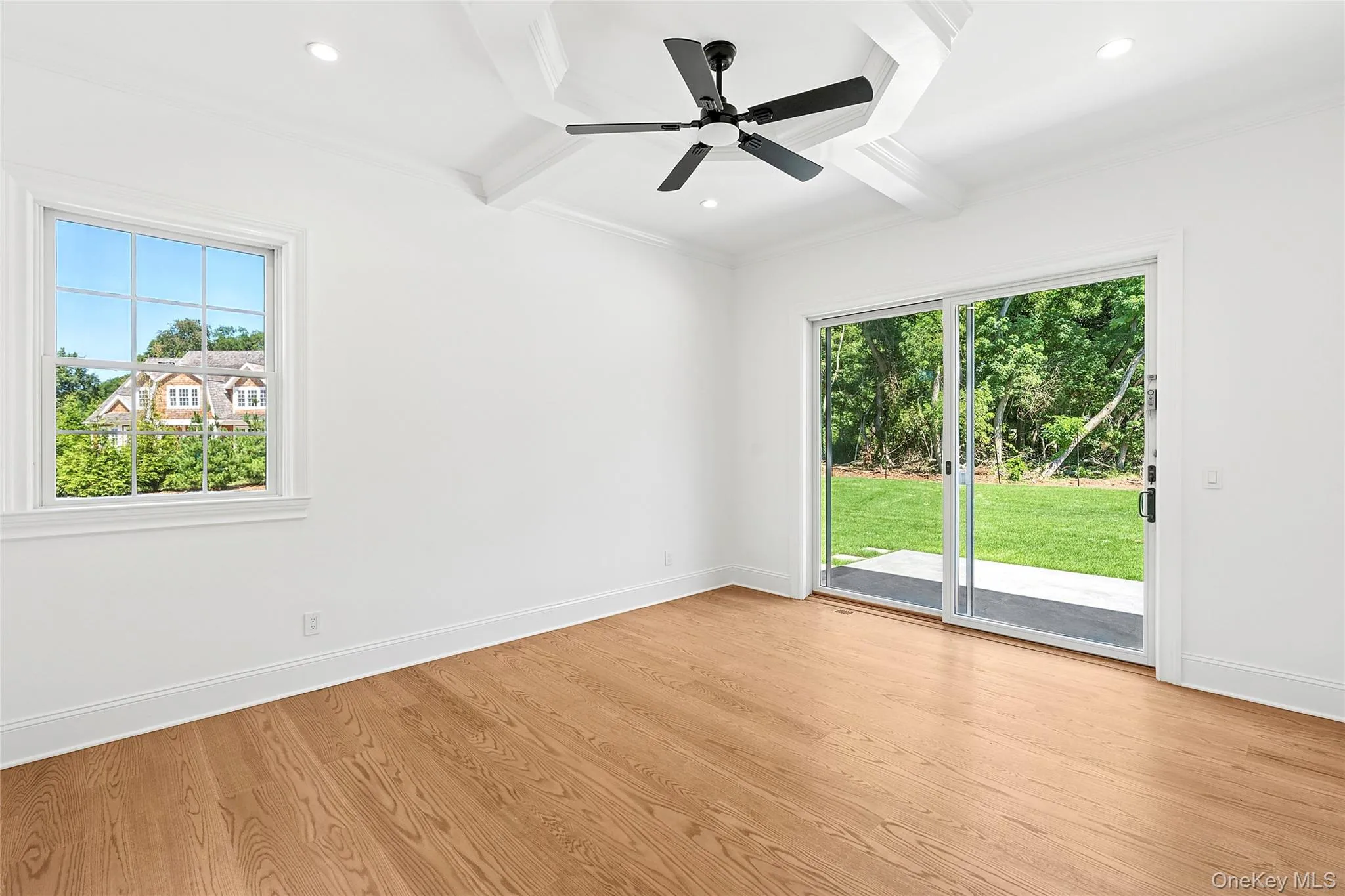 Unfurnished room with beamed ceiling, plenty of natural light, light wood-style floors, coffered ceiling, and crown molding Unfurnished room with beamed ceiling, plenty of natural light, light wood-style floors, coffered ceiling, and crown molding