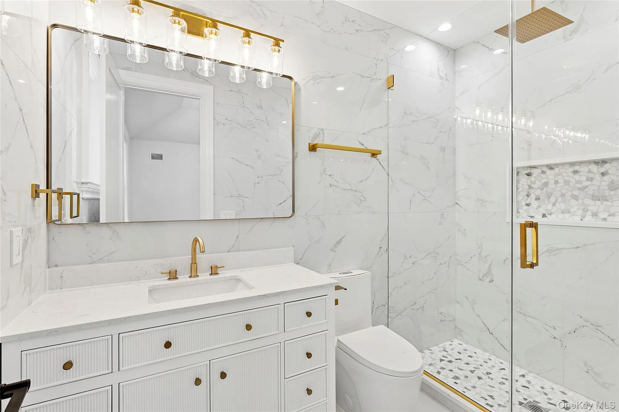 Full bathroom featuring a marble finish shower, vanity, tile walls, and recessed lighting Full bathroom featuring a marble finish shower, vanity, tile walls, and recessed lighting