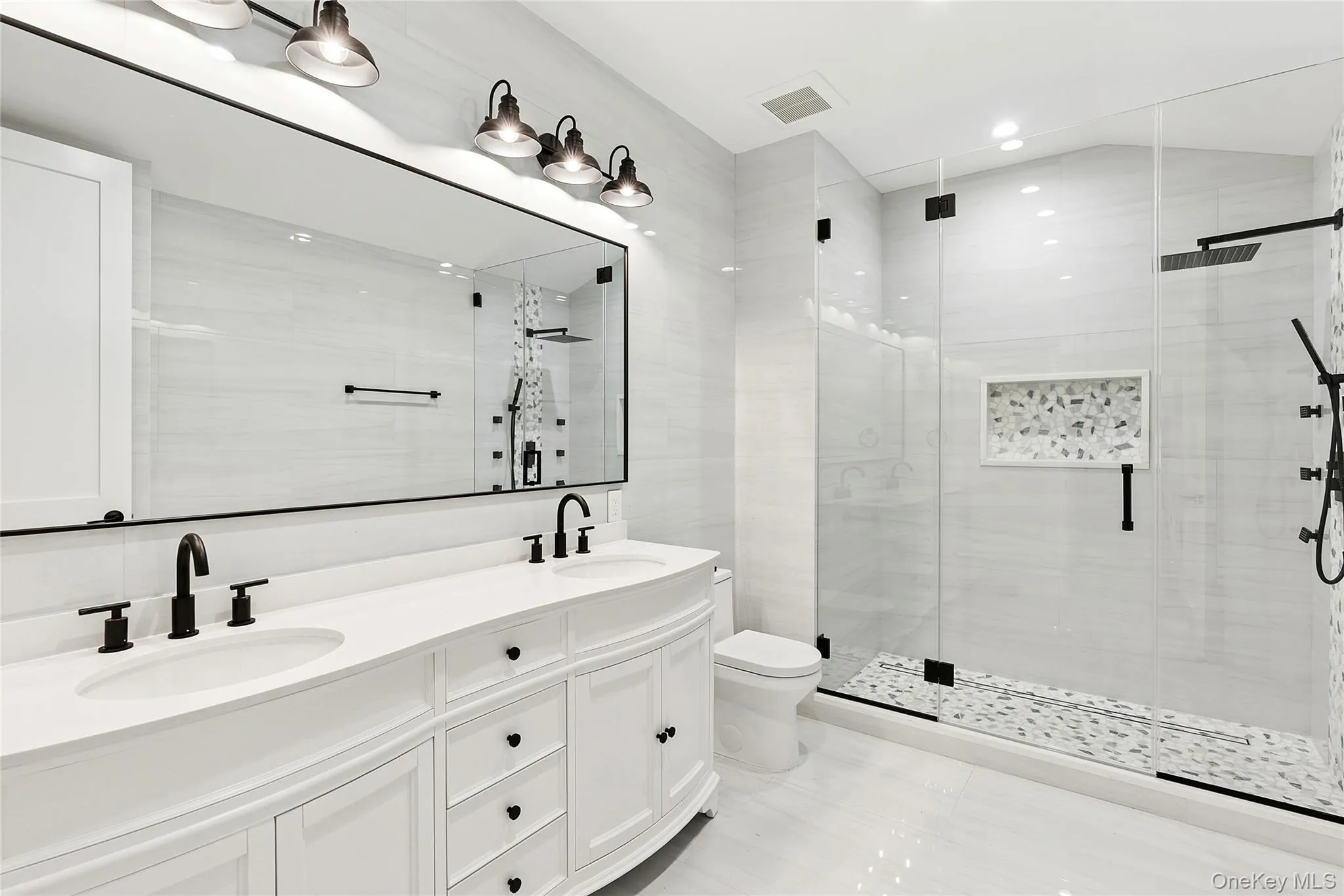 Bathroom featuring a stall shower and double vanity Bathroom featuring a stall shower and double vanity
