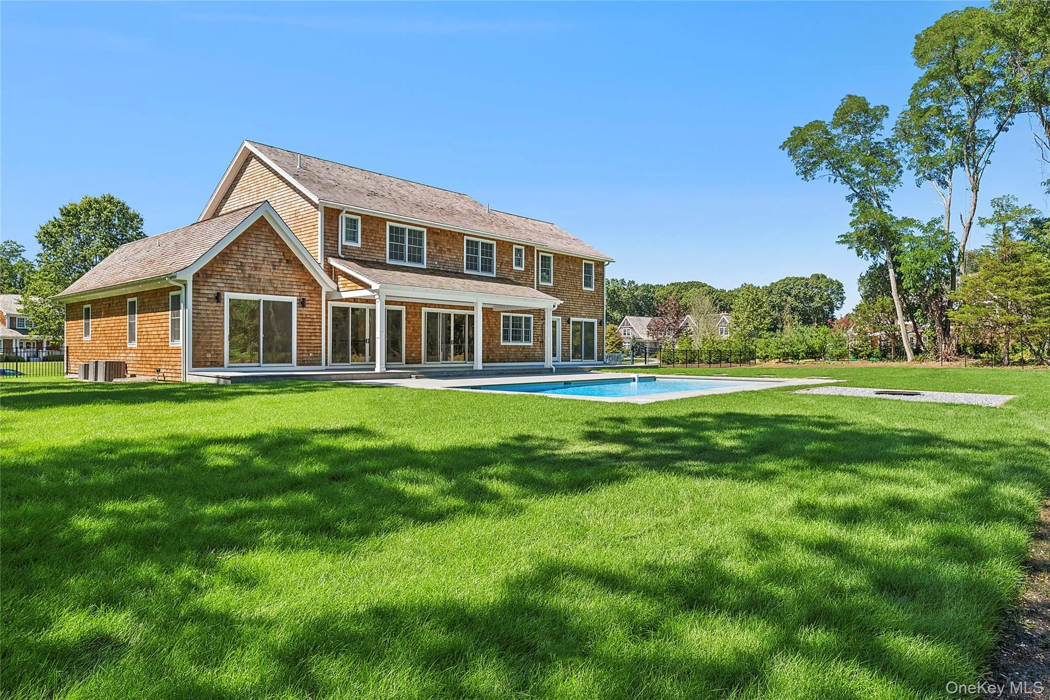 Rear view of house with a patio, an outdoor pool, and a yard Rear view of house with a patio, an outdoor pool, and a yard
