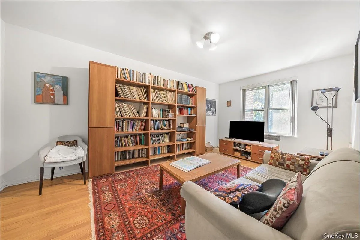 Living room with light wood finished floors and radiator heating unit Living room with light wood finished floors and radiator heating unit