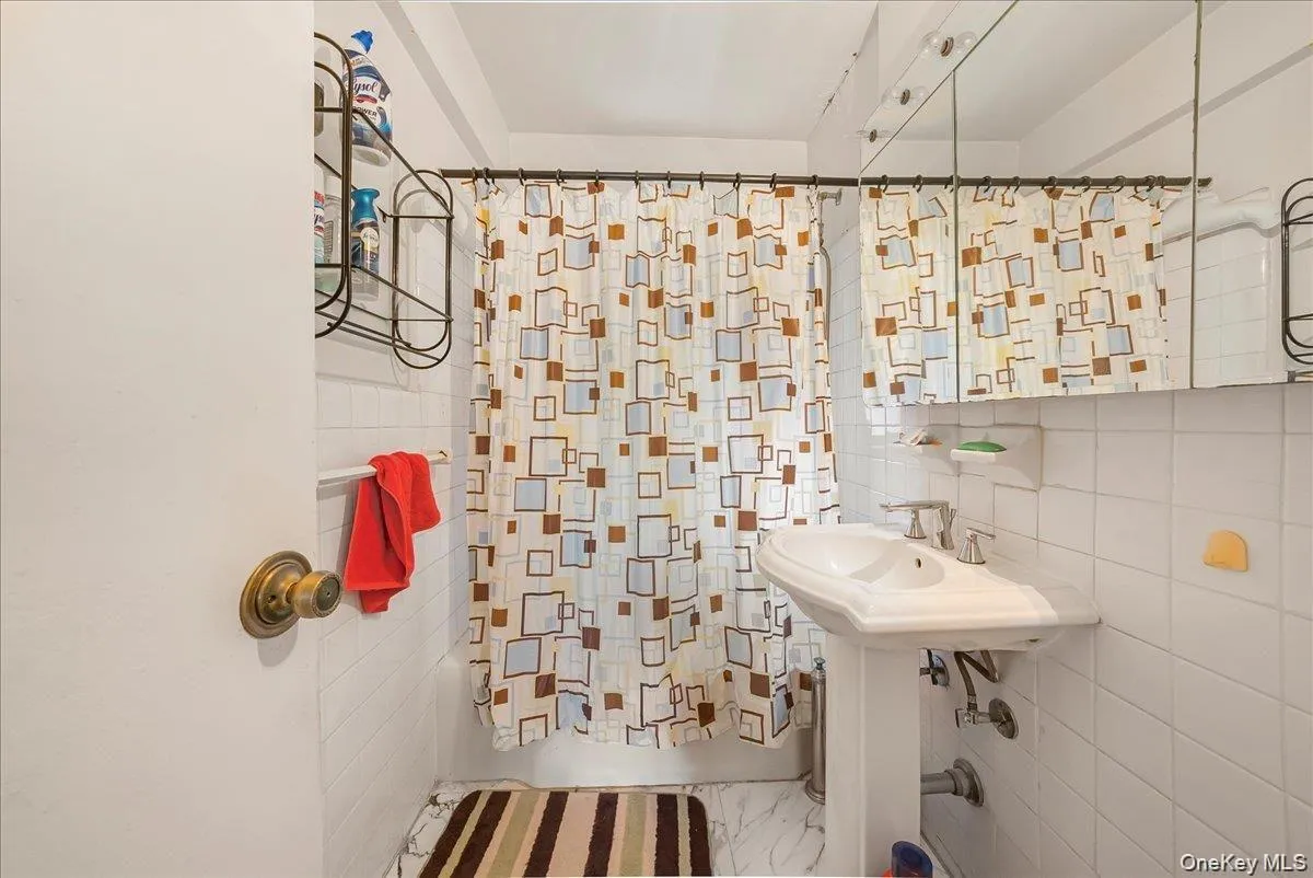 Bathroom with tile walls and shower / bath combination with curtain Bathroom with tile walls and shower / bath combination with curtain