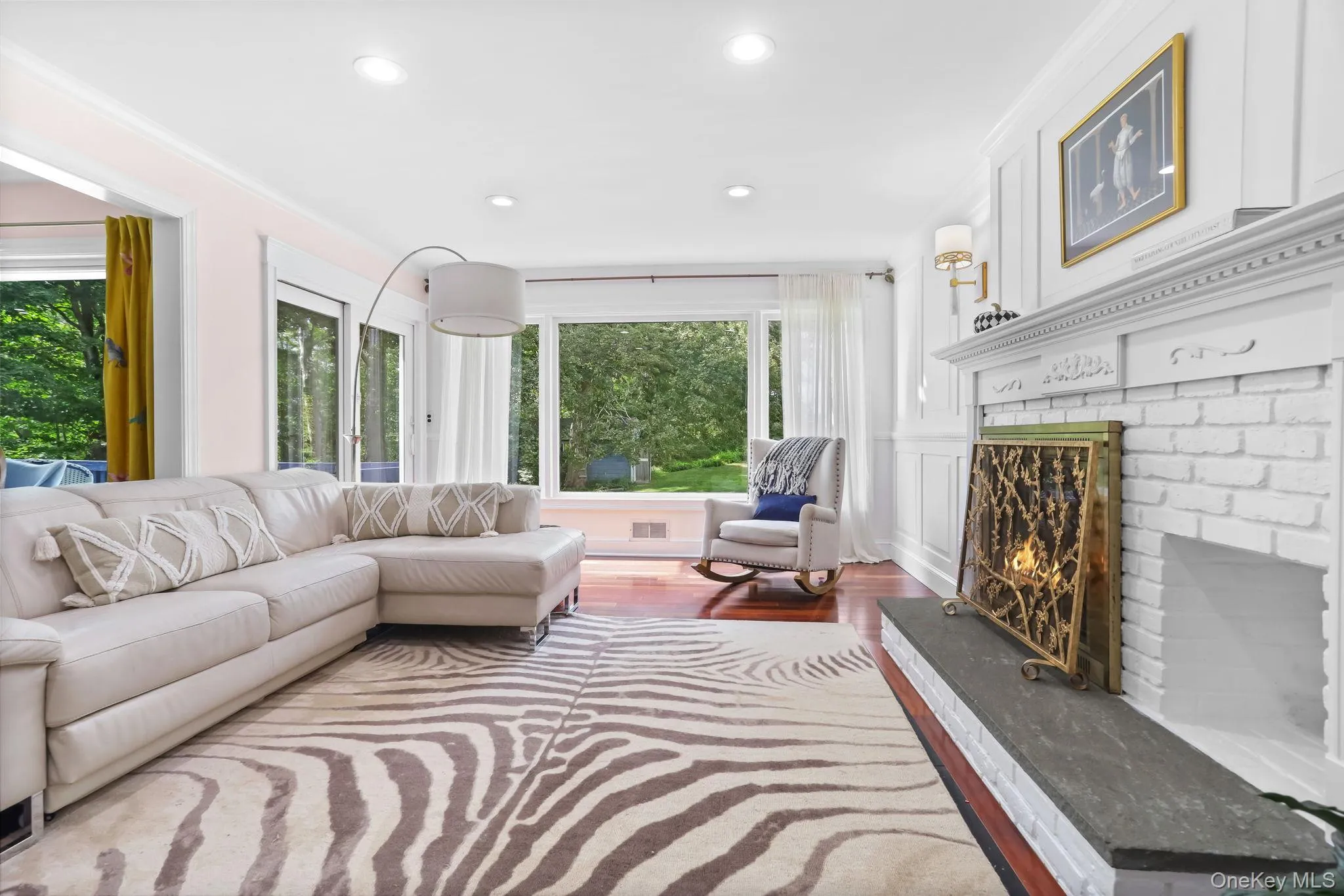 Living room with wood finished floors, recessed lighting, a fireplace, and ornamental molding Living room with wood finished floors, recessed lighting, a fireplace, and ornamental molding