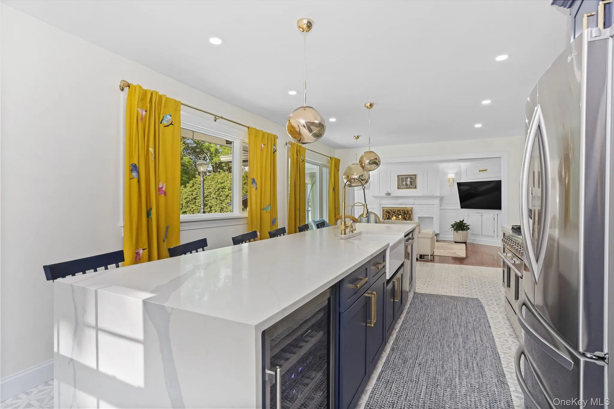 Kitchen featuring appliances with stainless steel finishes, light stone counters, blue cabinets, wine cooler, and pendant lighting Kitchen featuring appliances with stainless steel finishes, light stone counters, blue cabinets, wine cooler, and pendant lighting