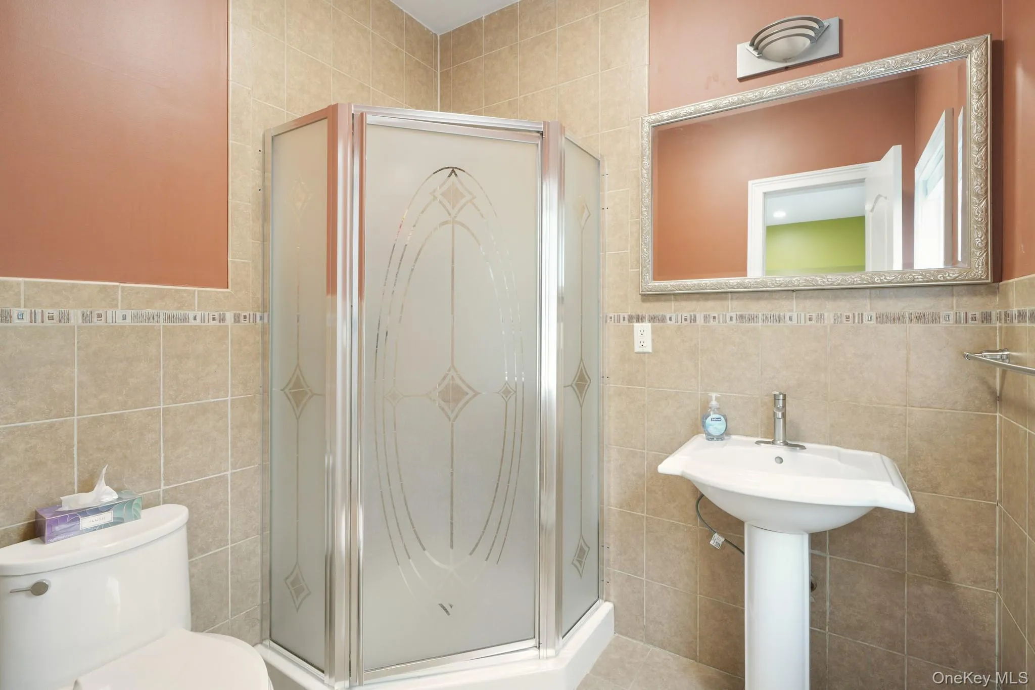 Full bathroom with tile walls and a shower stall Full bathroom with tile walls and a shower stall