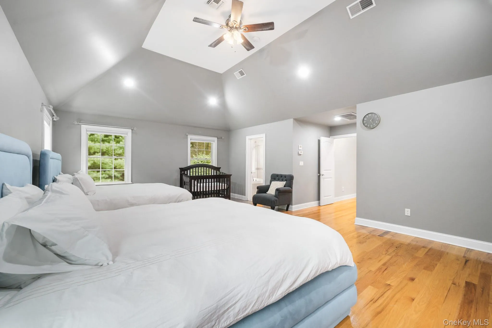 Bedroom featuring light wood-type flooring, lofted ceiling, and a ceiling fan Bedroom featuring light wood-type flooring, lofted ceiling, and a ceiling fan