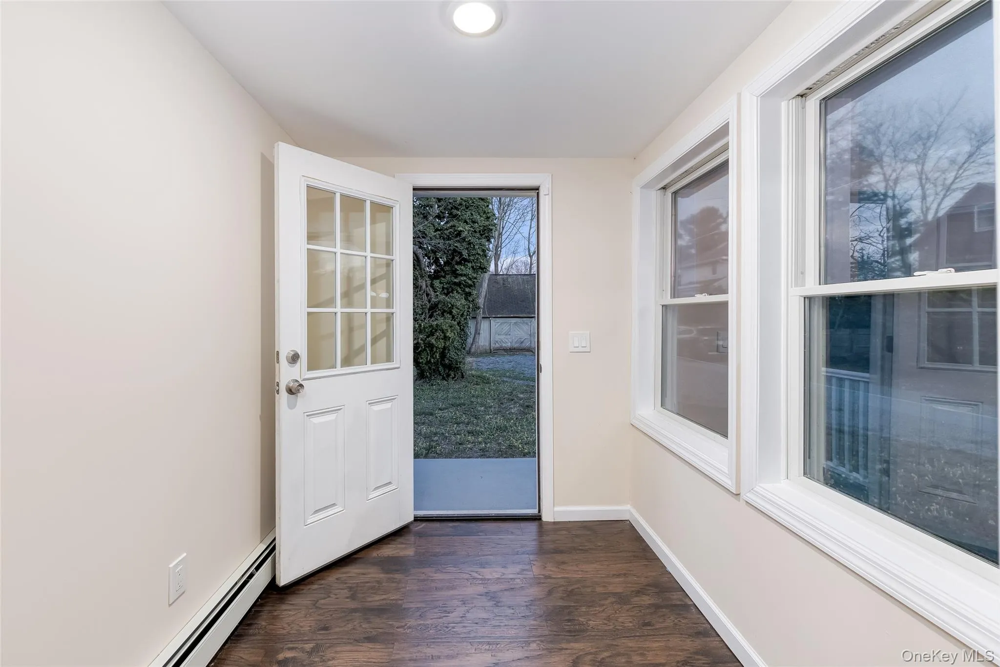 Doorway with wood finished floors and baseboard heating Doorway with wood finished floors and baseboard heating