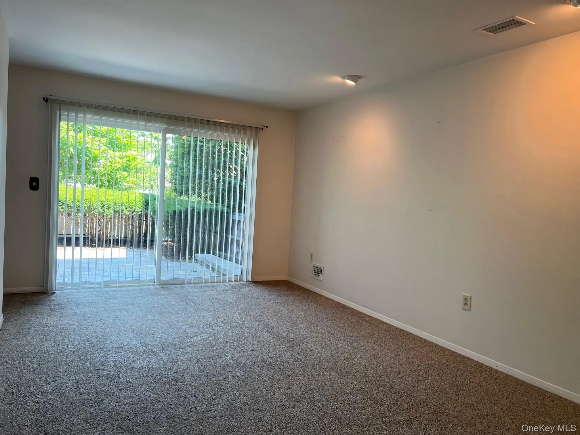 Unfurnished room with carpet flooring and baseboards Unfurnished room with carpet flooring and baseboards