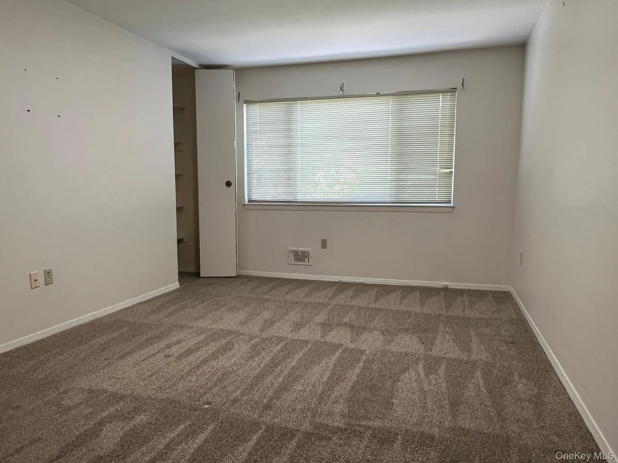 Spare room with carpet flooring and baseboards Spare room with carpet flooring and baseboards
