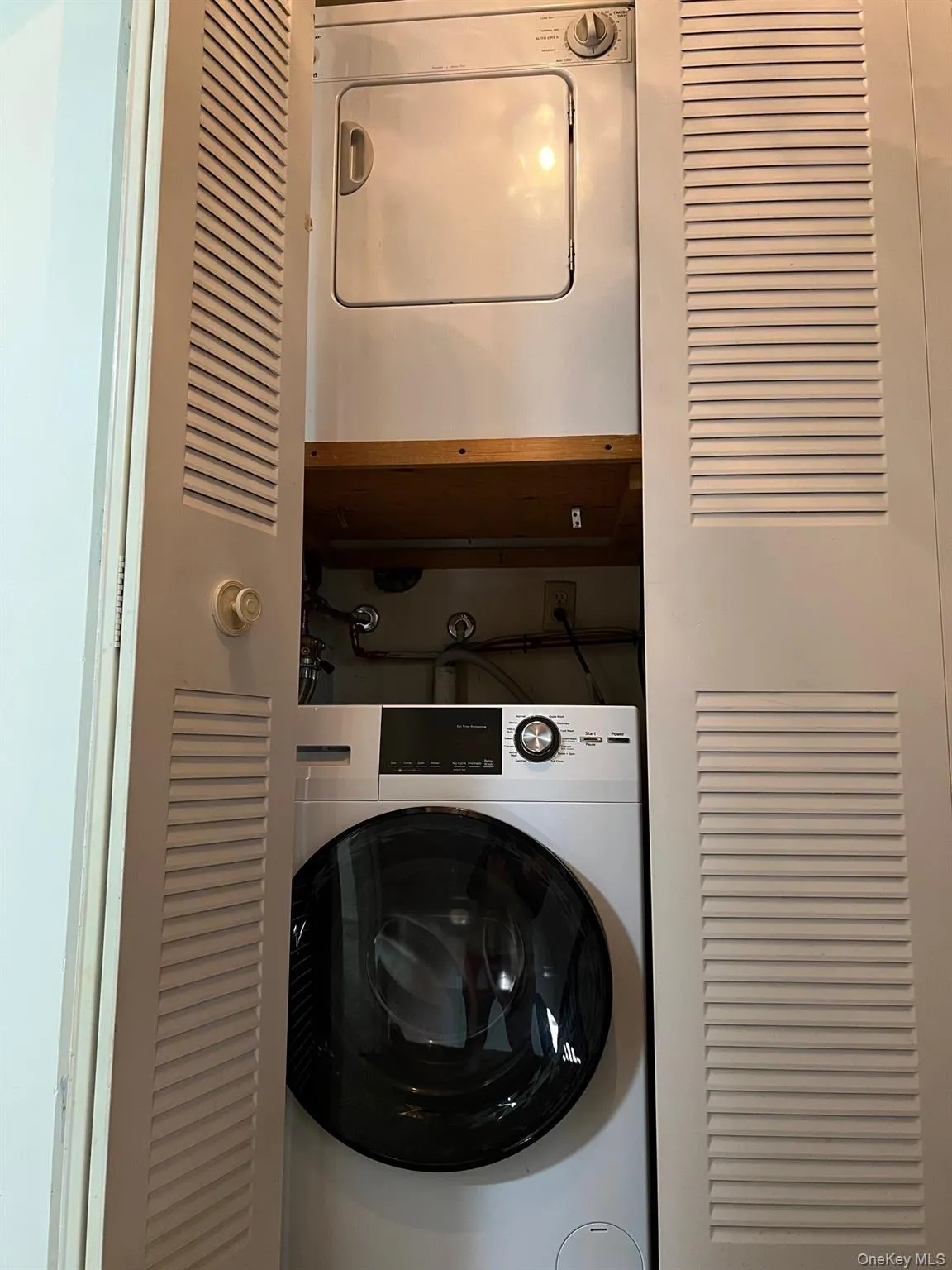 Laundry area featuring stacked washer and clothes dryer Laundry area featuring stacked washer and clothes dryer