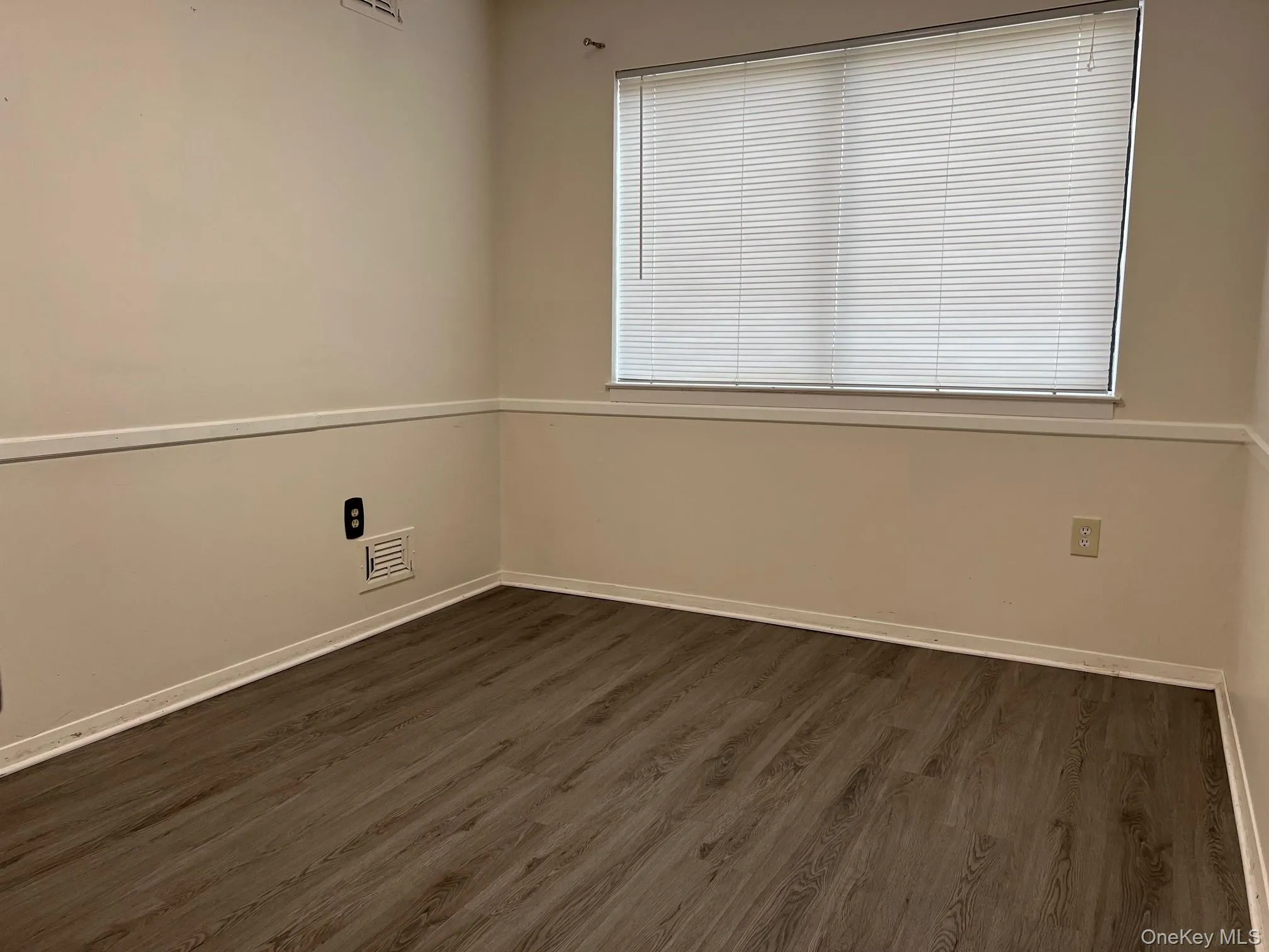Spare room featuring dark wood finished floors and baseboards Spare room featuring dark wood finished floors and baseboards