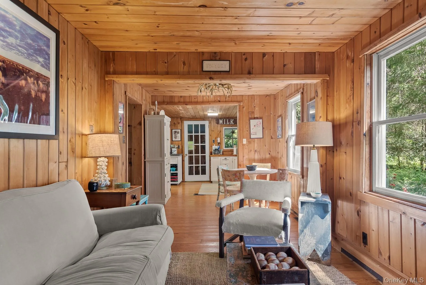 Living area with wood finished floors, wooden walls, and wooden ceiling Living area with wood finished floors, wooden walls, and wooden ceiling
