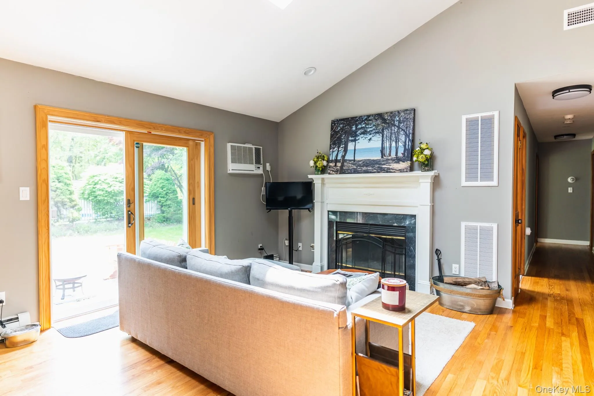 Living area with wood finished floors, a high end fireplace, healthy amount of natural light, high vaulted ceiling, and recessed lighting Living area with wood finished floors, a high end fireplace, healthy amount of natural light, high vaulted ceiling, and recessed lighting