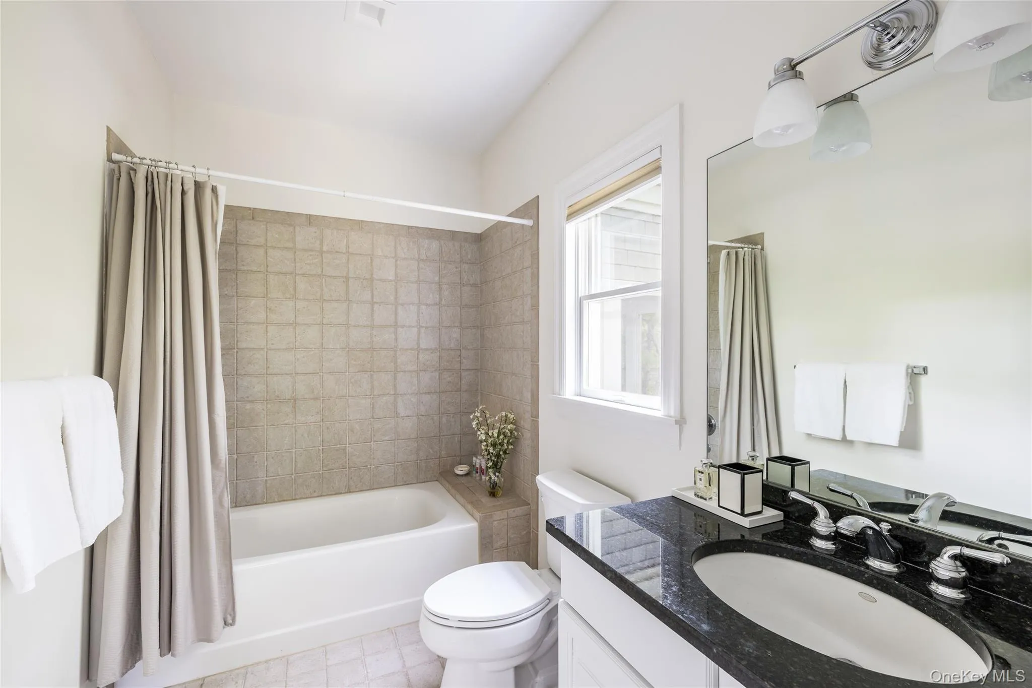 Bathroom featuring shower / bath combo with shower curtain, vanity, and light tile patterned flooring Bathroom featuring shower / bath combo with shower curtain, vanity, and light tile patterned flooring