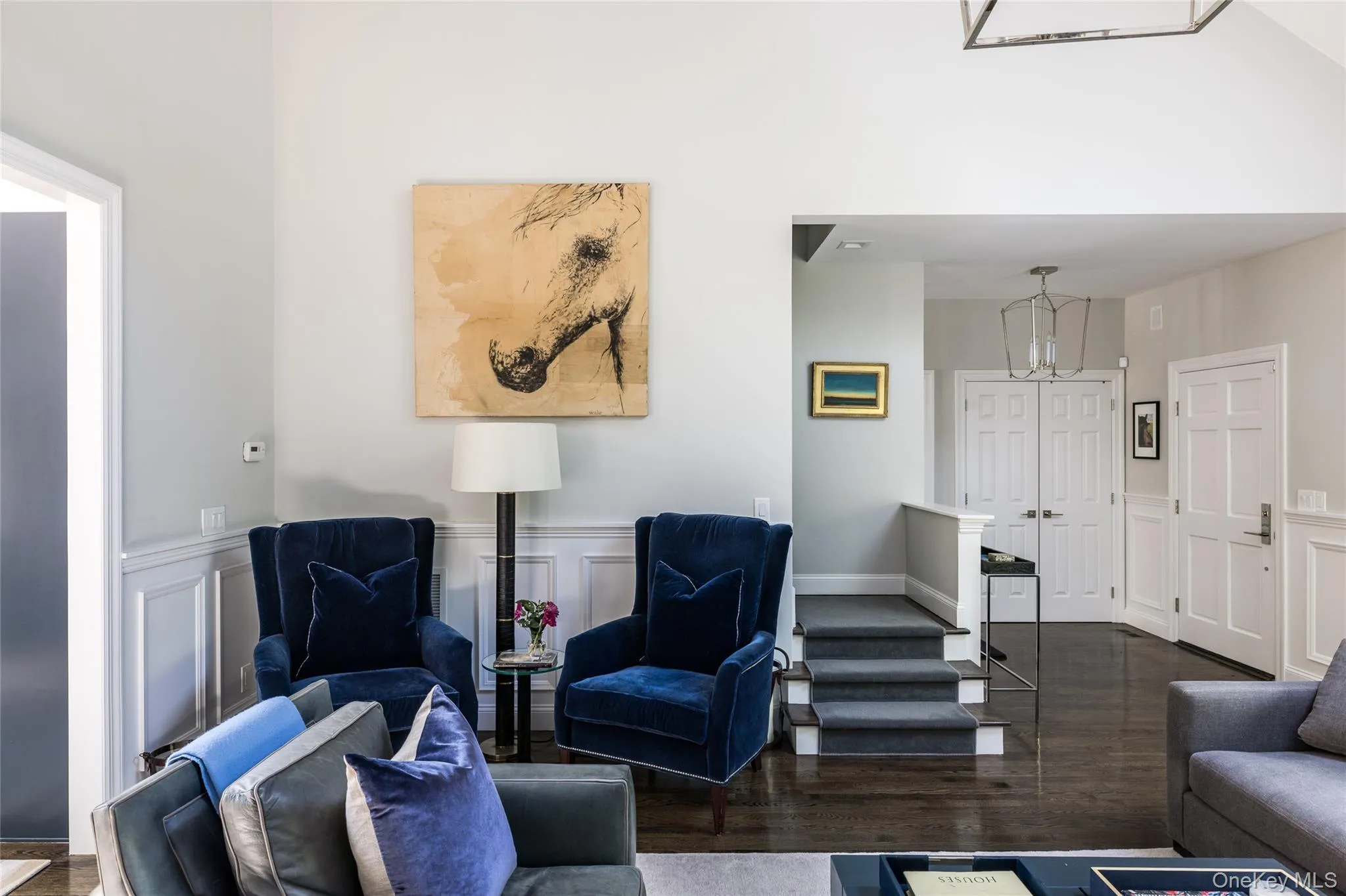 Living area featuring a decorative wall, a wainscoted wall, and dark wood-style floors Living area featuring a decorative wall, a wainscoted wall, and dark wood-style floors