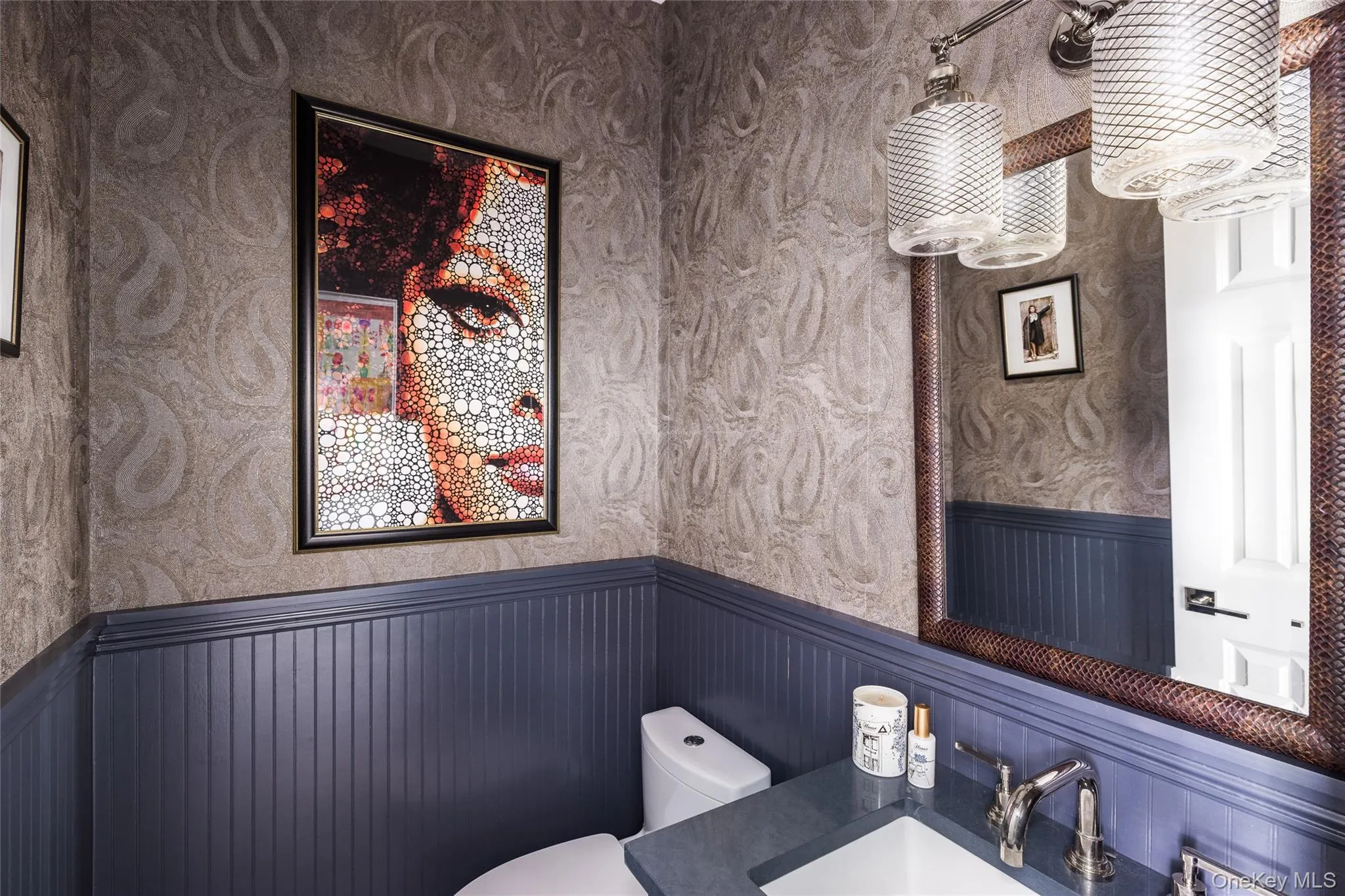 Half bath with wallpapered walls, wainscoting, and vanity Half bath with wallpapered walls, wainscoting, and vanity
