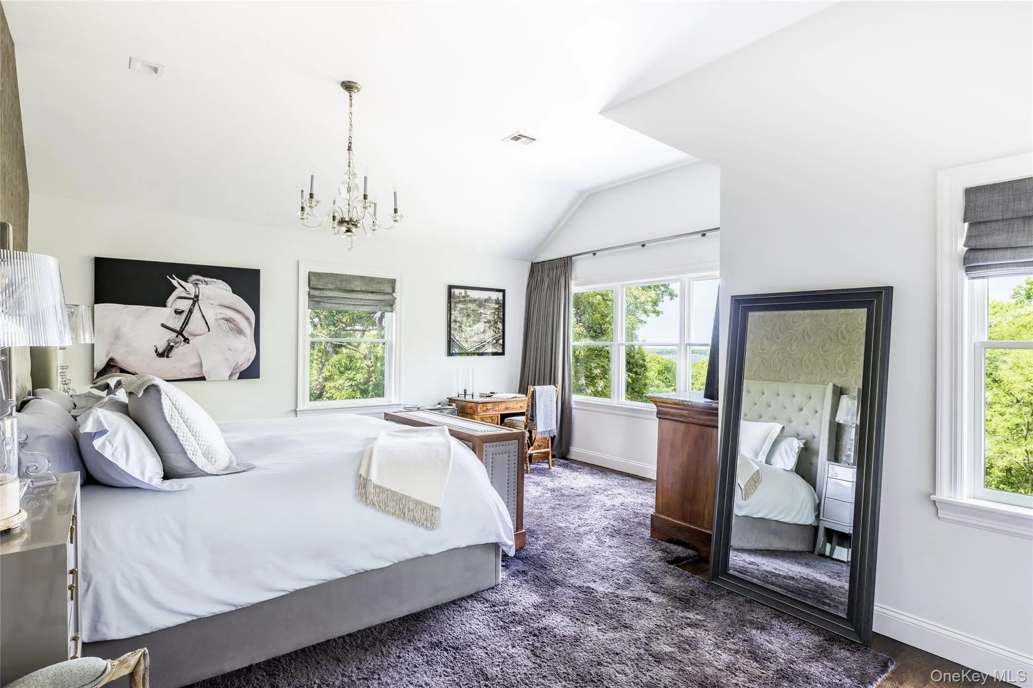 Bedroom featuring lofted ceiling, a chandelier, and dark colored carpet Bedroom featuring lofted ceiling, a chandelier, and dark colored carpet