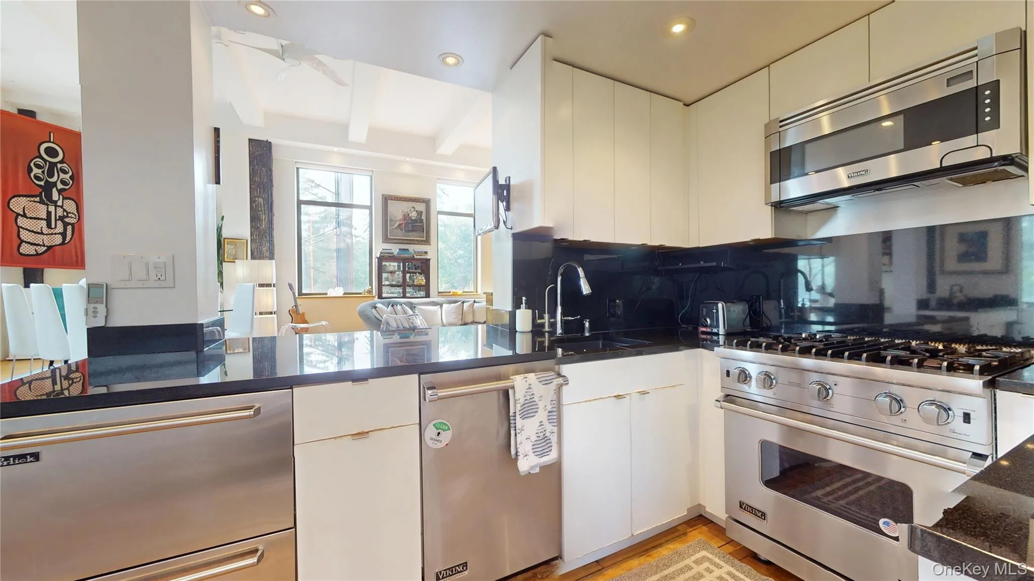 Kitchen featuring stainless steel appliances, tasteful backsplash, beamed ceiling, white cabinetry, and recessed lighting Kitchen featuring stainless steel appliances, tasteful backsplash, beamed ceiling, white cabinetry, and recessed lighting