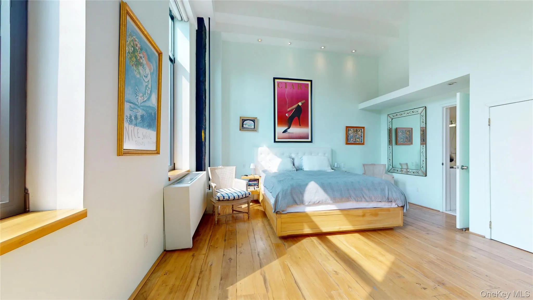 Bedroom with light wood finished floors and a high ceiling Bedroom with light wood finished floors and a high ceiling