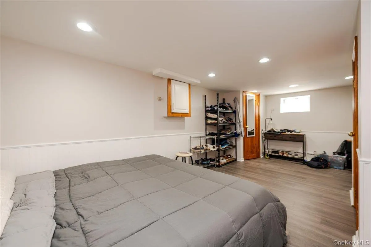 Bedroom with a wainscoted wall, wood finished floors, and recessed lighting Bedroom with a wainscoted wall, wood finished floors, and recessed lighting