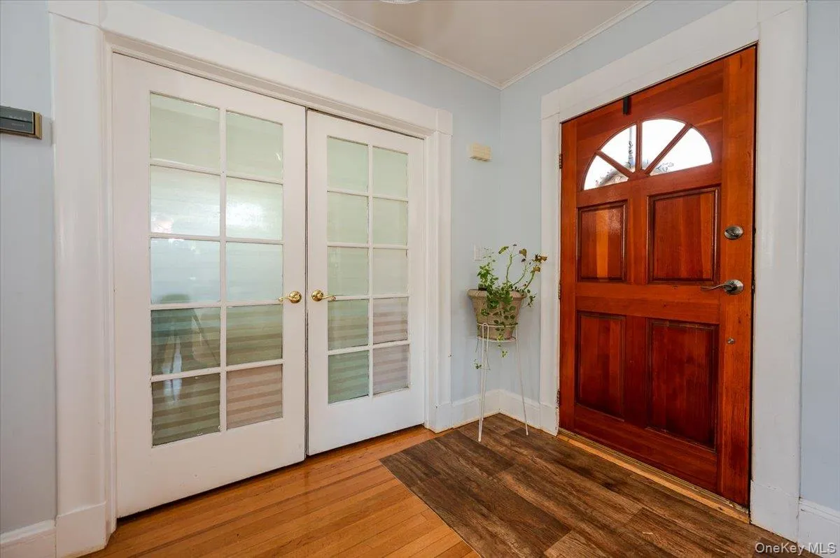 Entrance foyer with wood finished floors, french doors, and crown molding Entrance foyer with wood finished floors, french doors, and crown molding