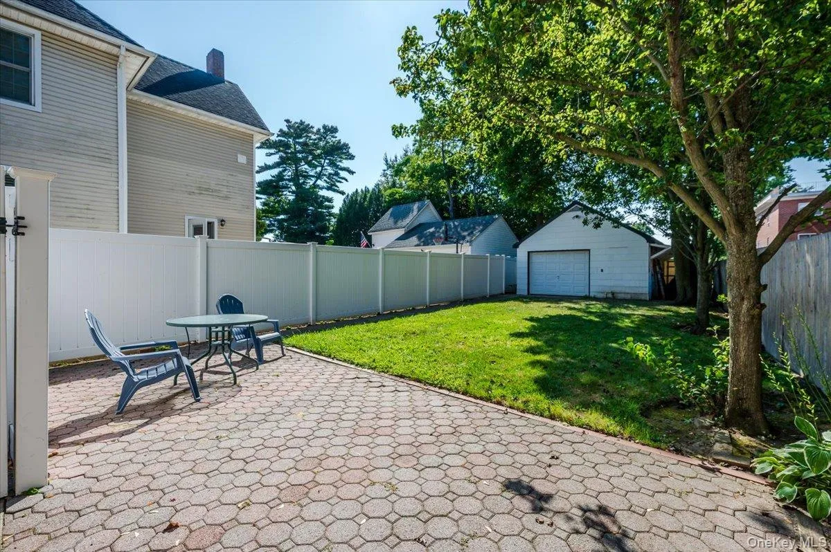 Fenced backyard featuring a patio area and an outbuilding Fenced backyard featuring a patio area and an outbuilding