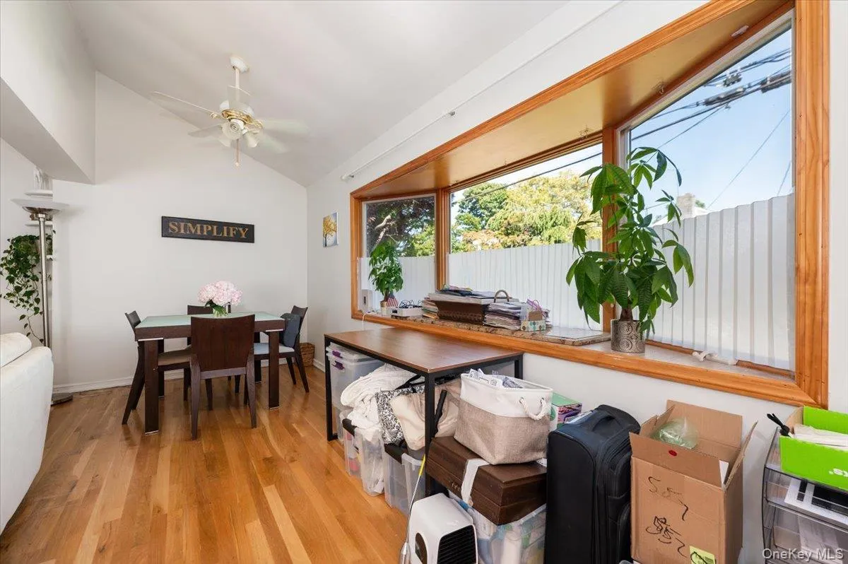 Dining room featuring vaulted ceiling, light wood finished floors, and a ceiling fan Dining room featuring vaulted ceiling, light wood finished floors, and a ceiling fan