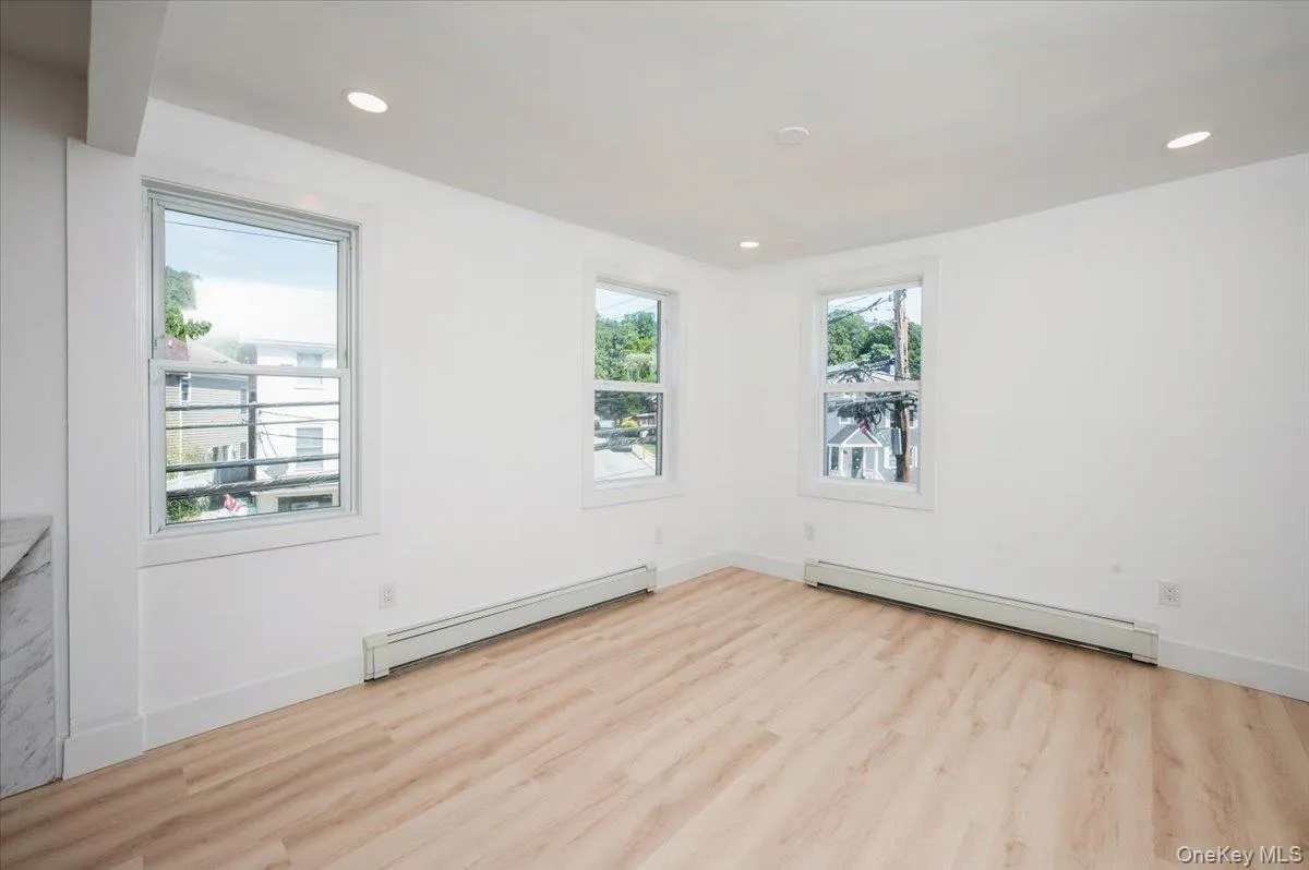 Unfurnished room featuring a baseboard heating unit, light wood-style flooring, and recessed lighting Unfurnished room featuring a baseboard heating unit, light wood-style flooring, and recessed lighting